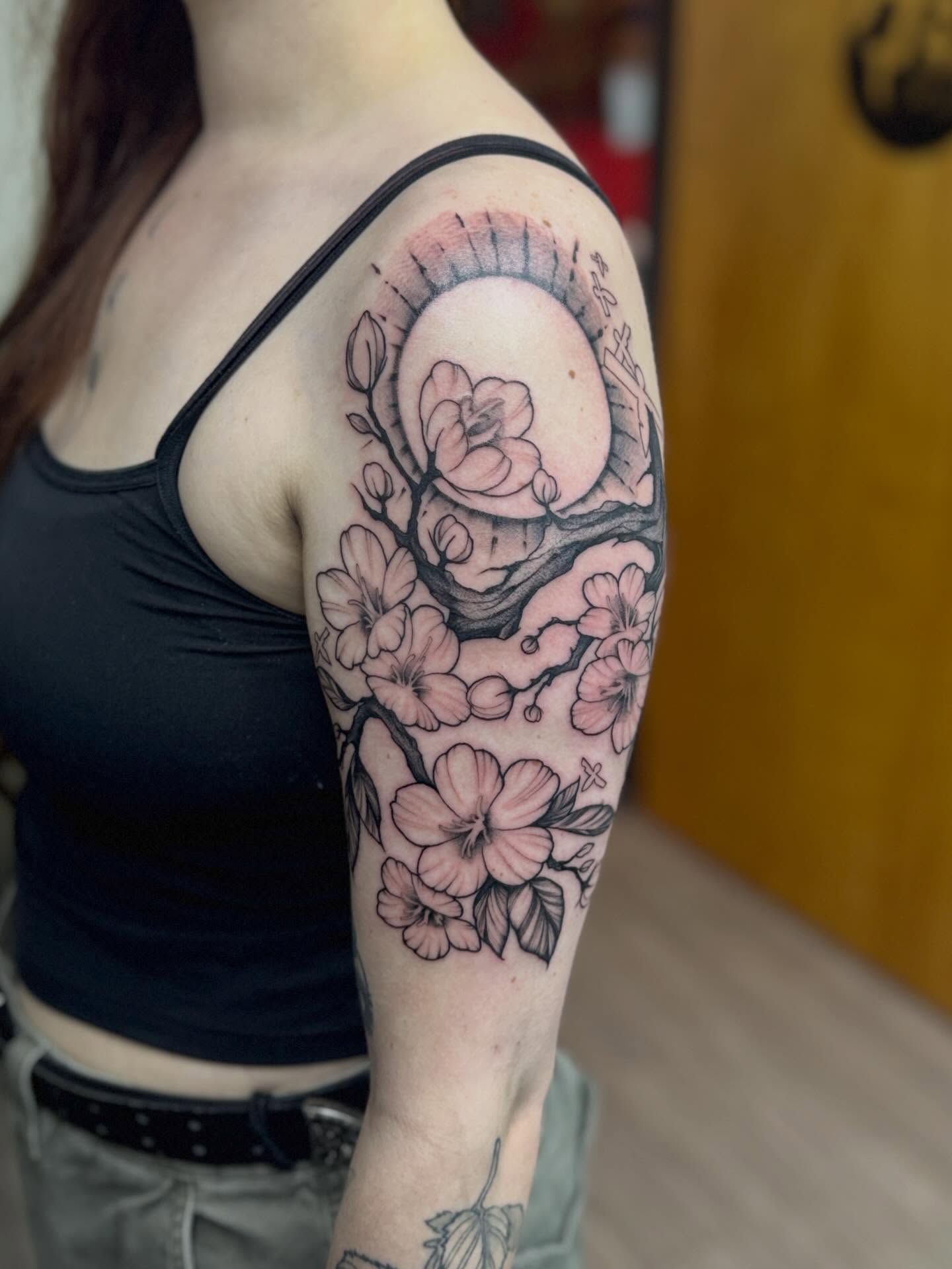 Cherry blossoms and moon realism tattoo on the upper arm by Rebecca Rose