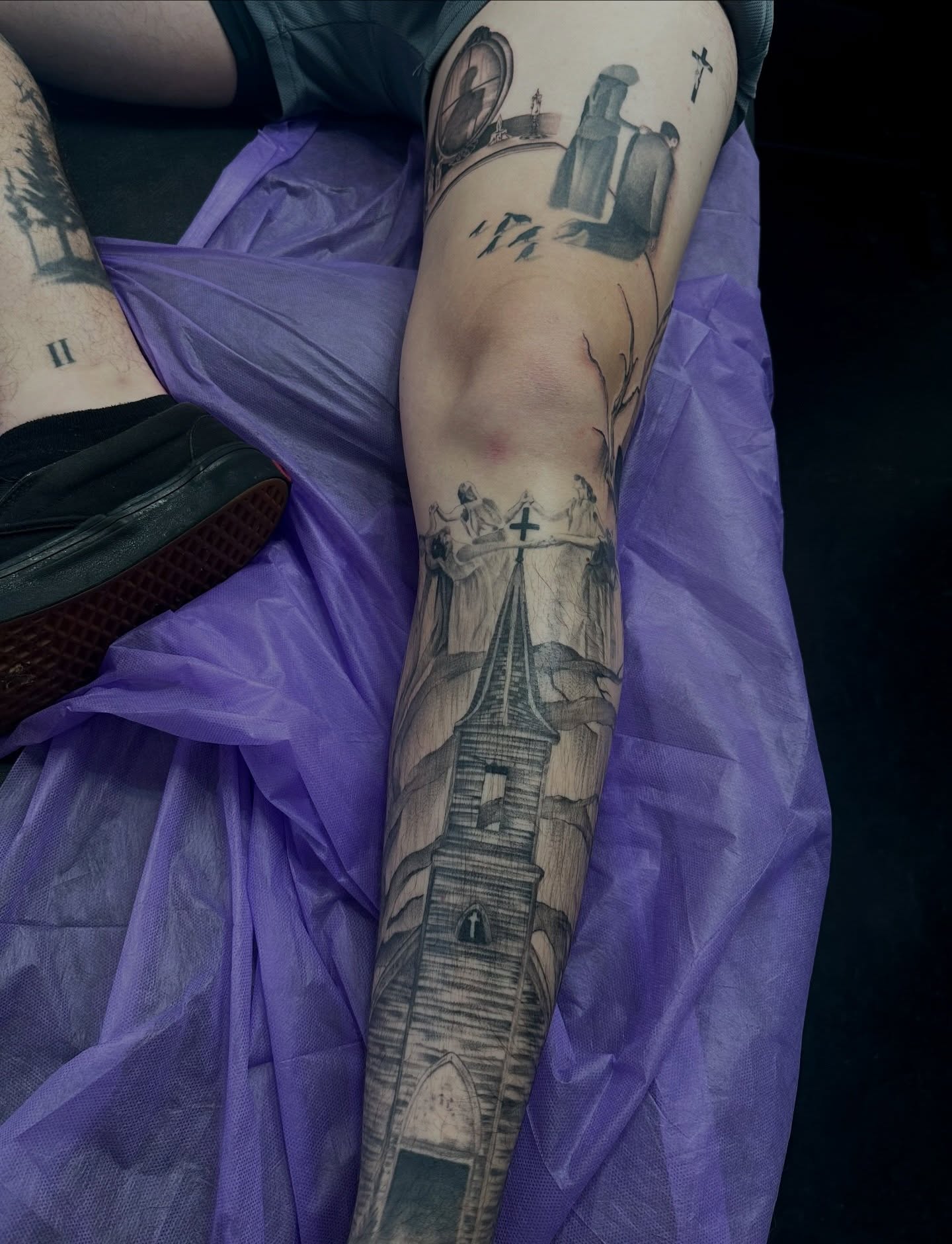 Church tower and religious figures realism tattoo on the forearm by Macy Rae