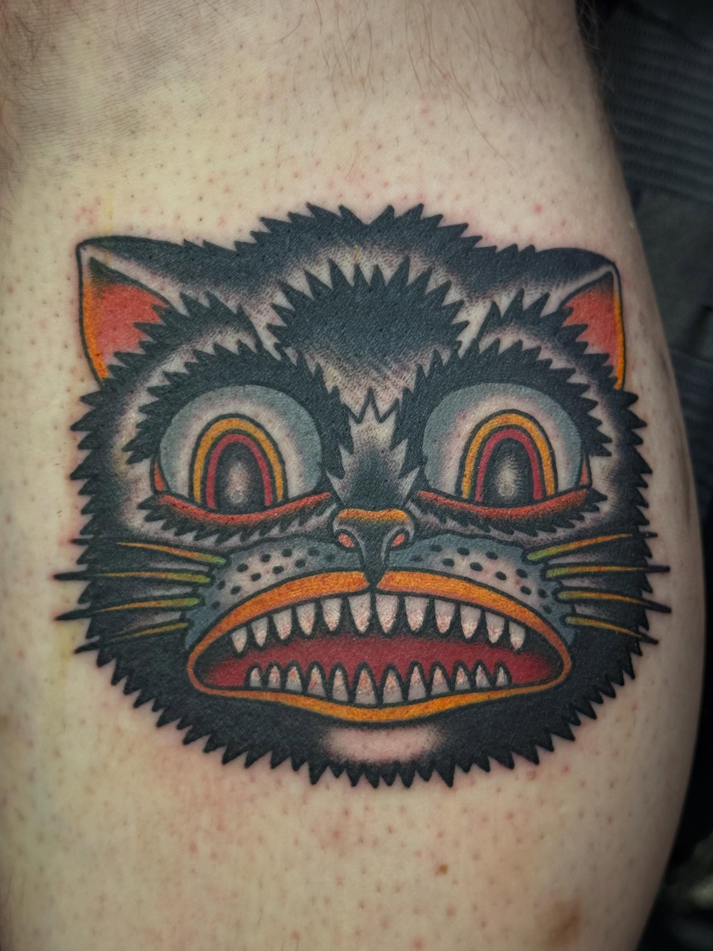 Cat face American traditional tattoo on the thigh by Laurent Trelaun, San Francisco, California