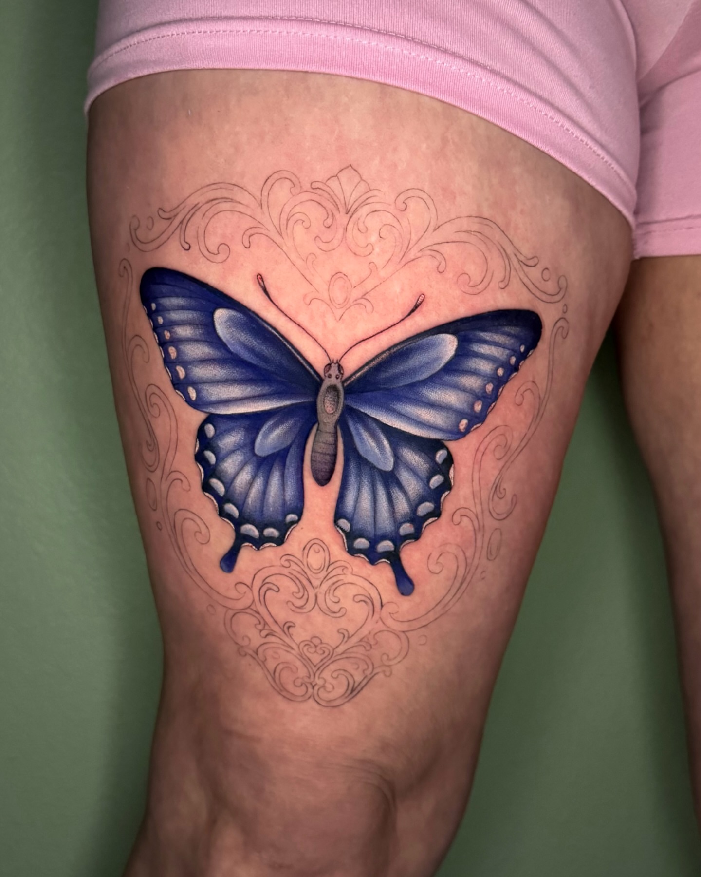 Blue butterfly realism tattoo on the thigh by Nichole Lorence