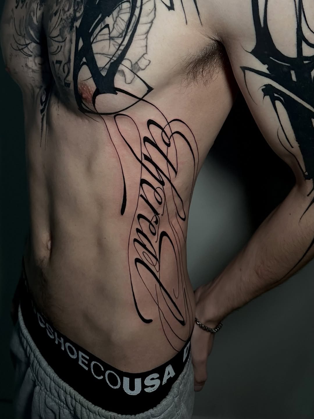 Script lettering on torso Chicano tattoo on the torso by Crystal, Las Vegas, Nevada