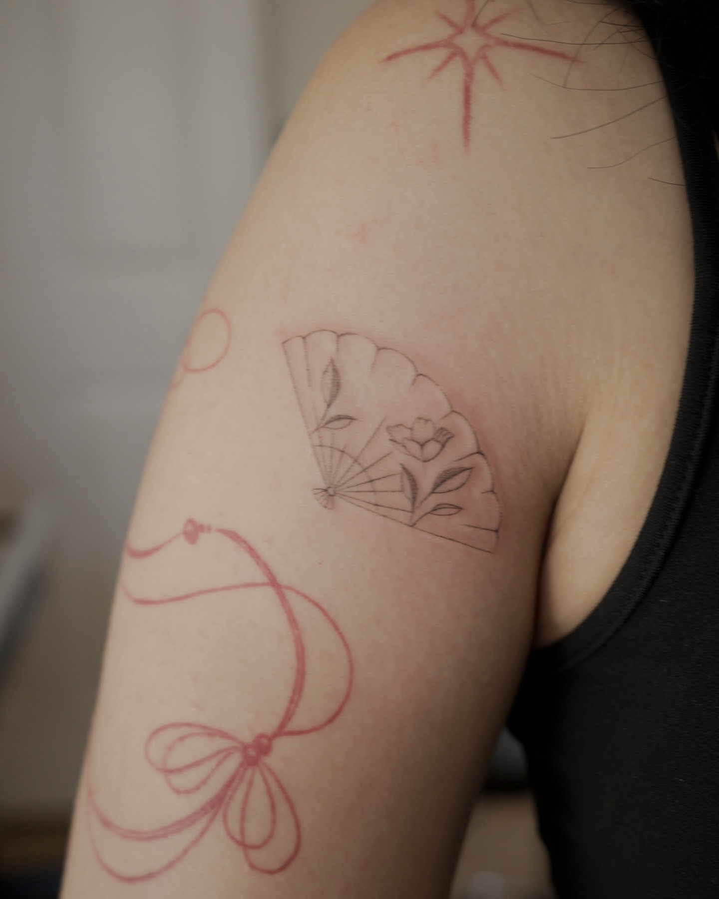 Flower and butterfly fine line tattoo on the upper arm by It’s ya girl, KB