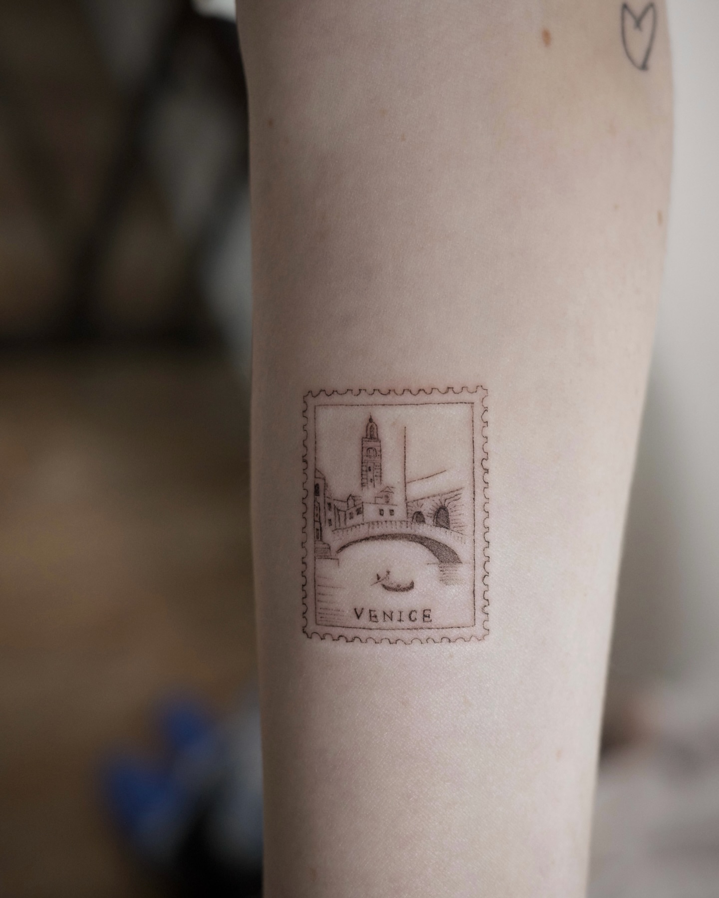 Venice stamp black and grey tattoo on the forearm by It’s ya girl, KB