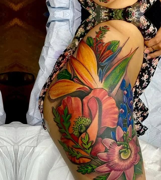 Colorful floral arrangement neo-traditional tattoo on the thigh by Raheem Jacobs, Austin, Texas