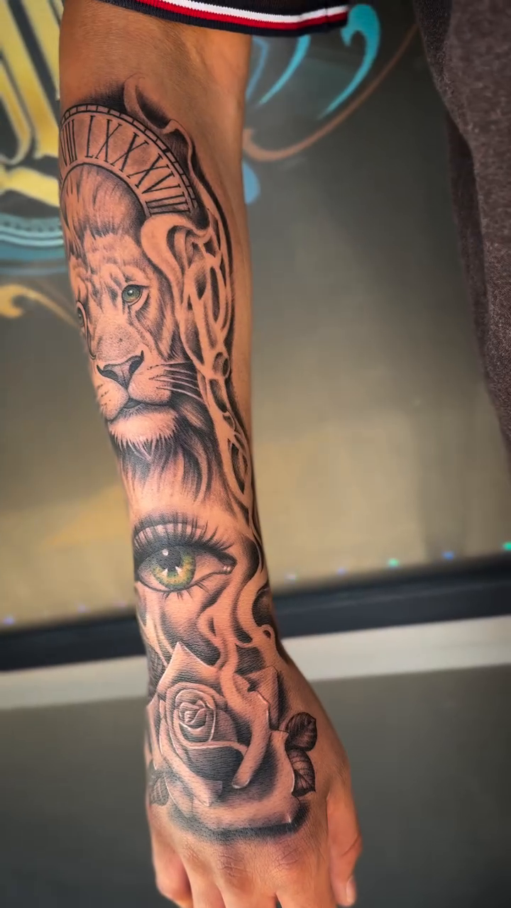 Lion, eye, and roses sleeve Japanese tattoo on the forearm by Monica Gonzalez