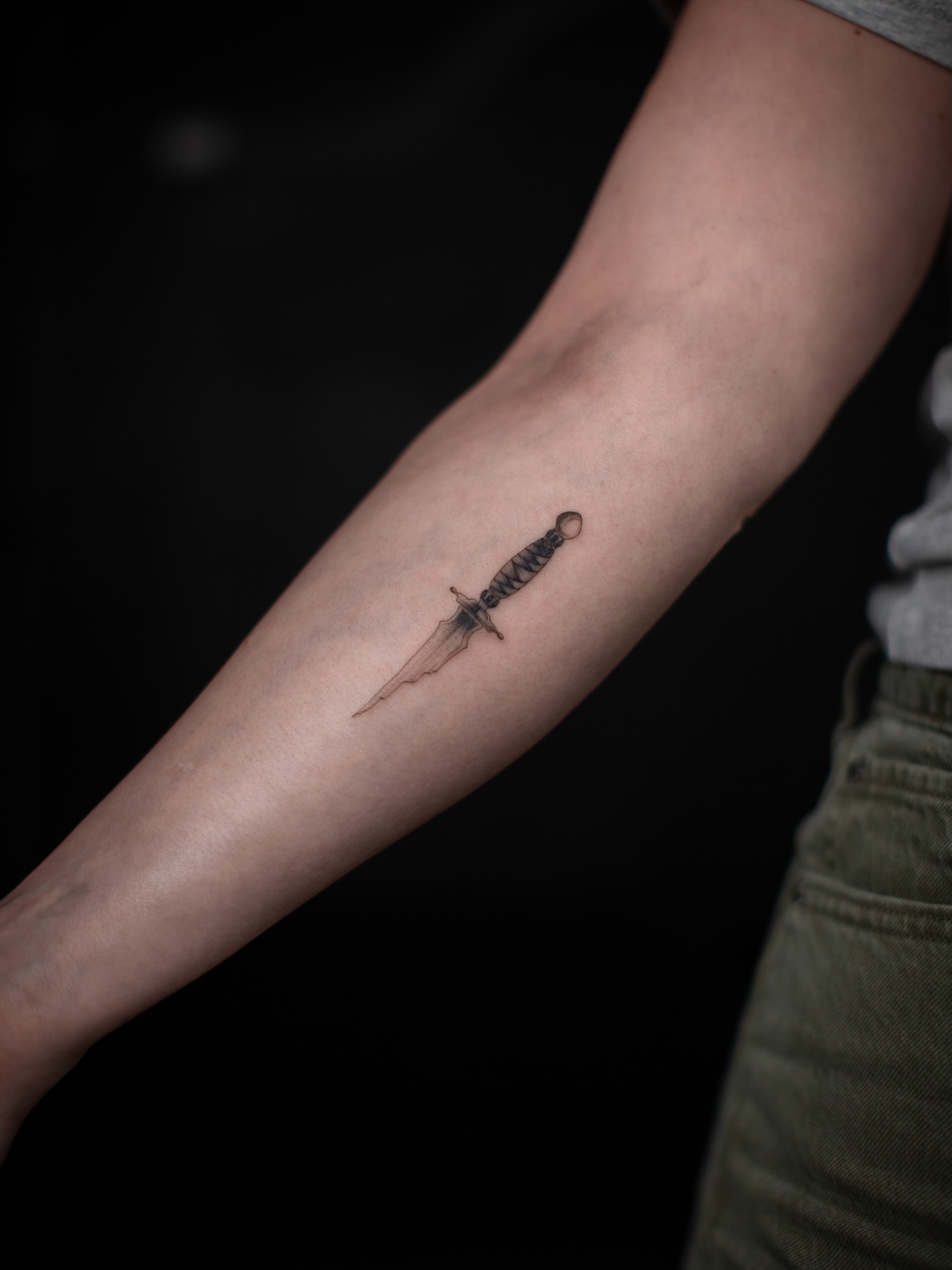 Sword black and grey tattoo on the forearm by Aries Rising