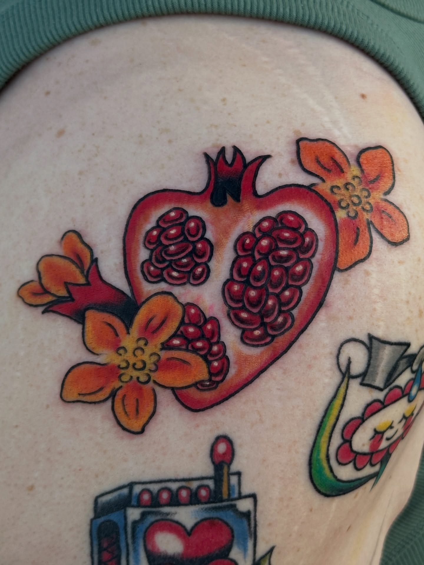 Pomegranate and flowers American traditional tattoo on the torso by julian solis, Houston, Texas