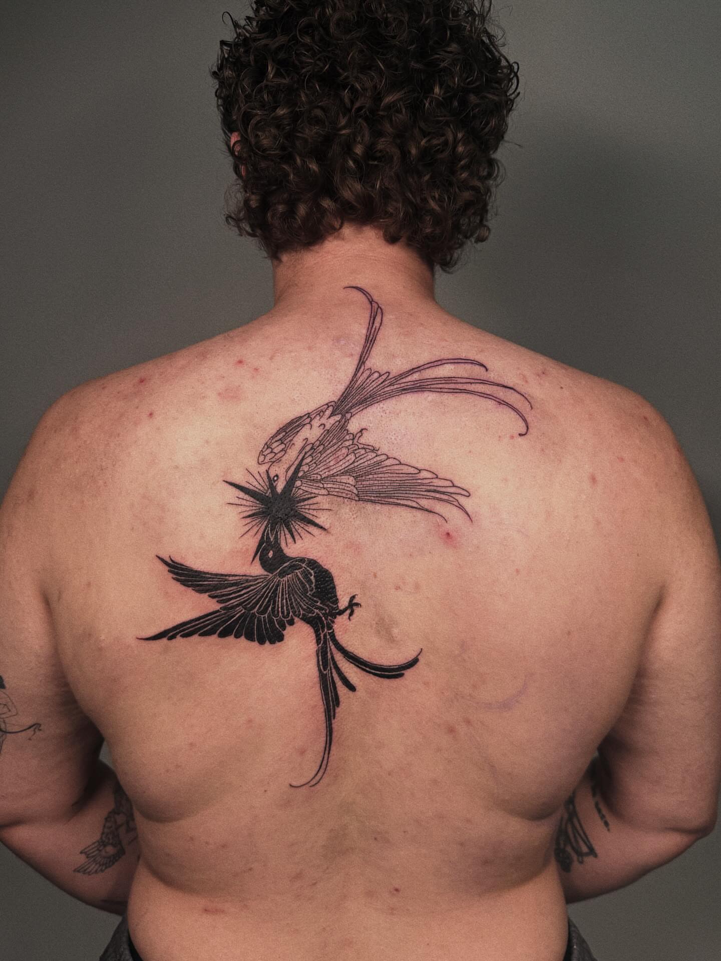 Bird and flower black and grey tattoo on the back by Paulina Vazquez