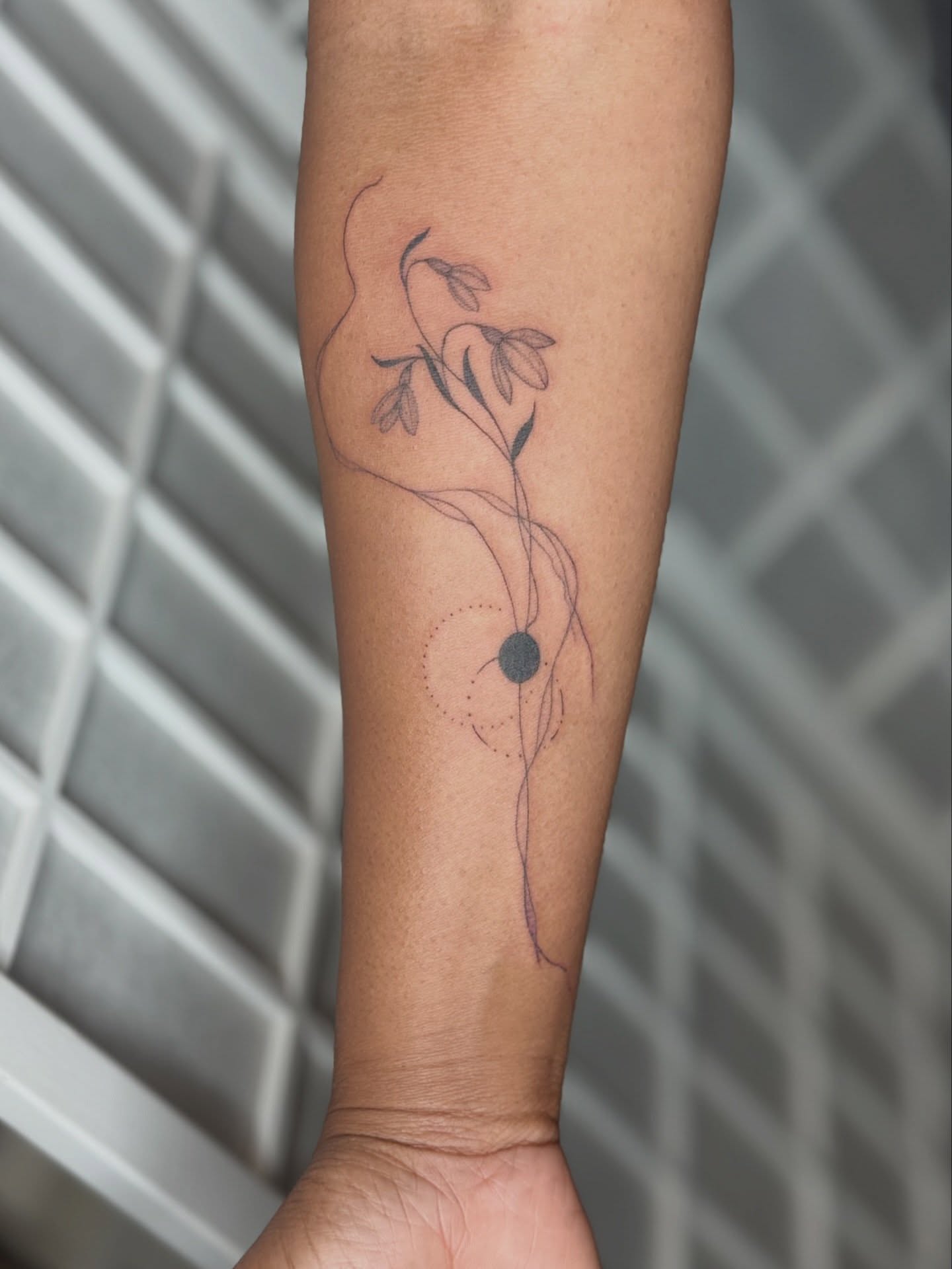 Floral design fine line tattoo on the forearm by Dama