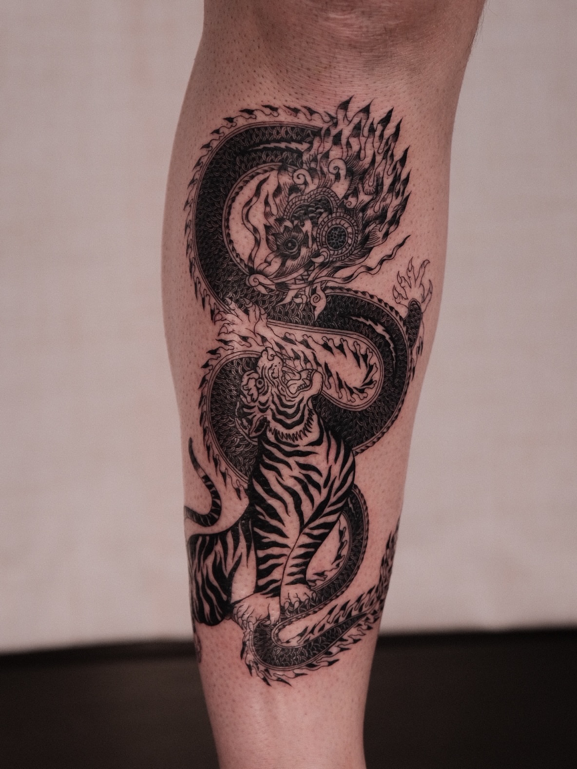 Dragon and tiger realism tattoo on the calf by Houston Tattoo Artist GoldenK