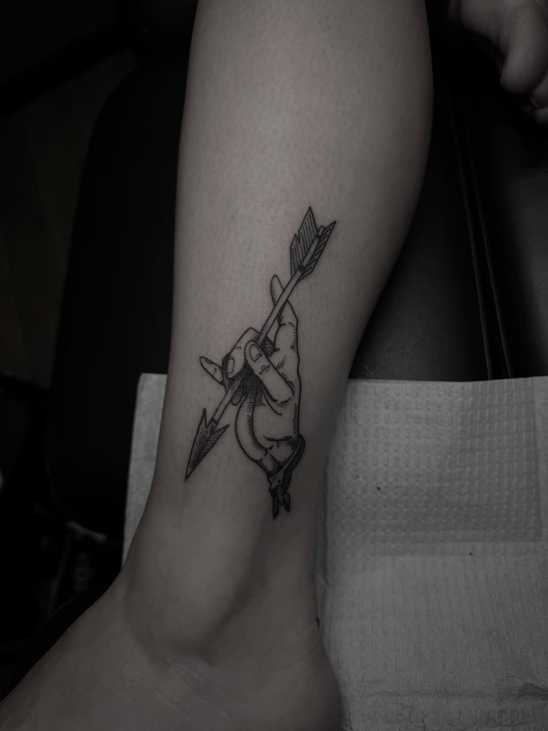 Hand holding arrow ignorant tattoo on the forearm by Joe Khay, Hackettstown, New Jersey
