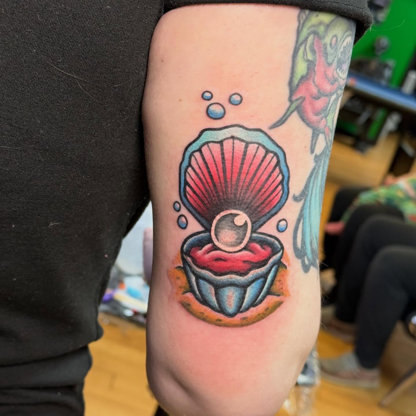 Shell and pearl American traditional tattoo on the forearm by Nic