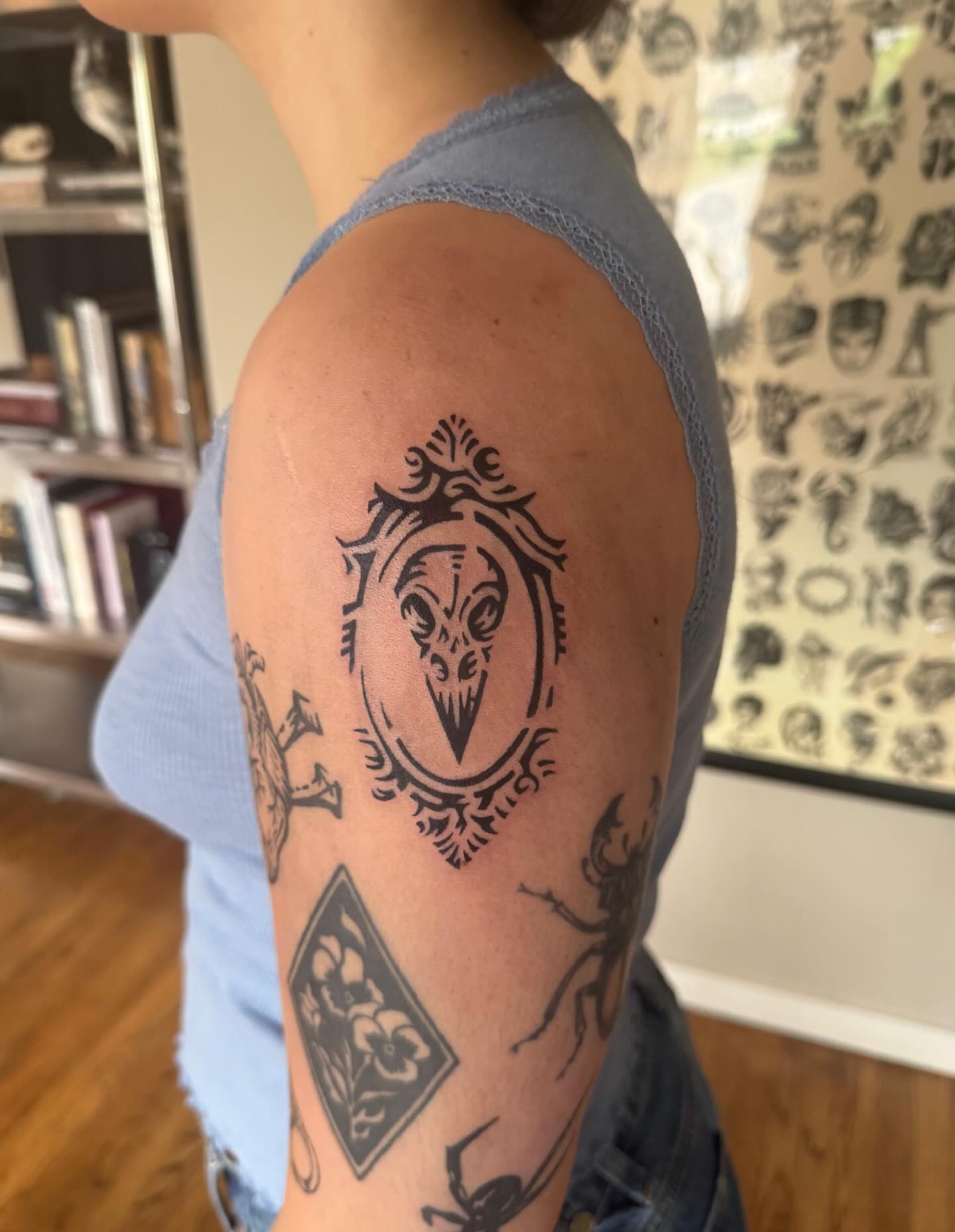Gothic mask geometric tattoo on the upper arm by M