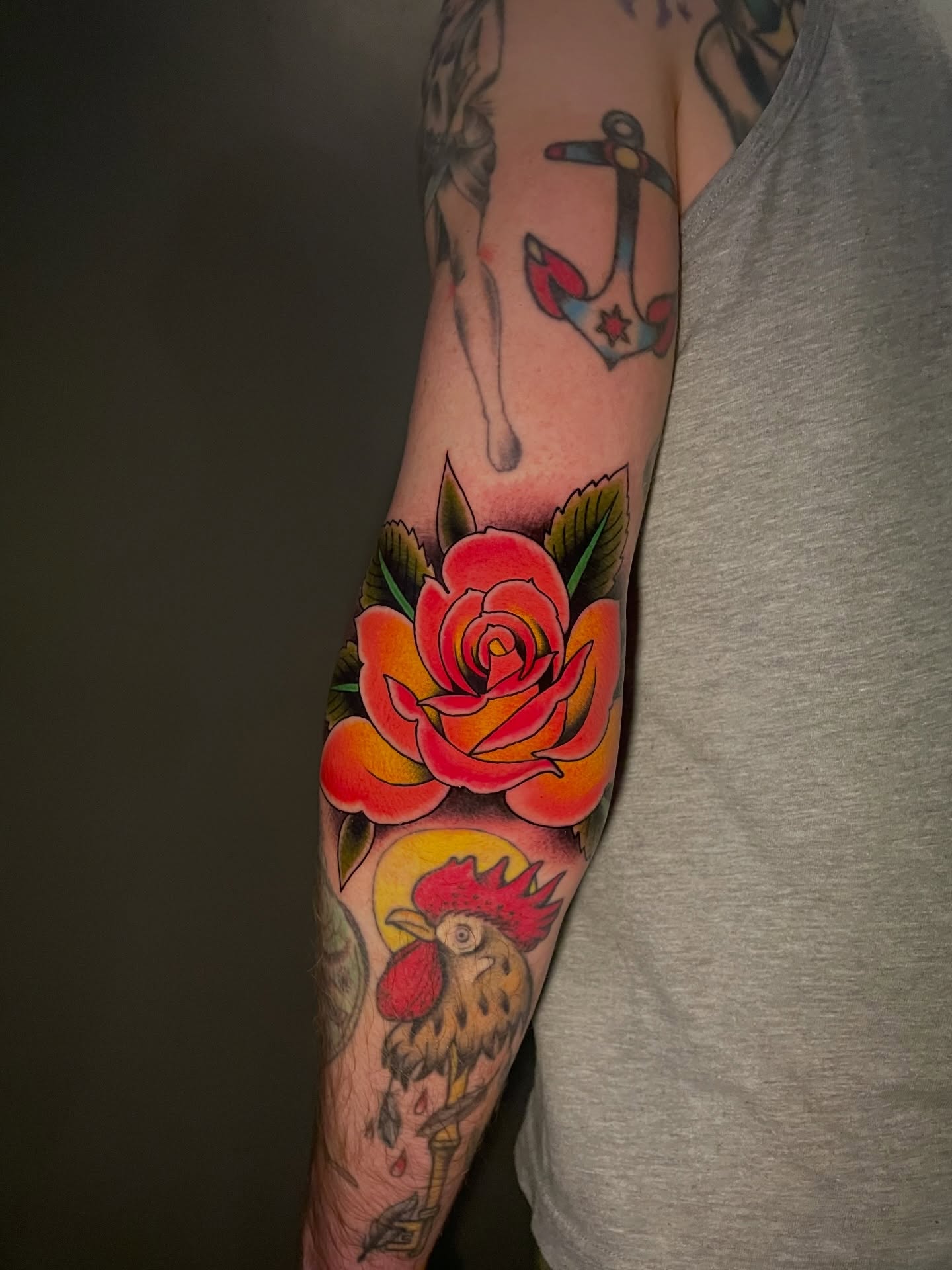 Rose and rooster American traditional tattoo on the forearm by Ｊｉｍ Ｓｙｌｖｉａ