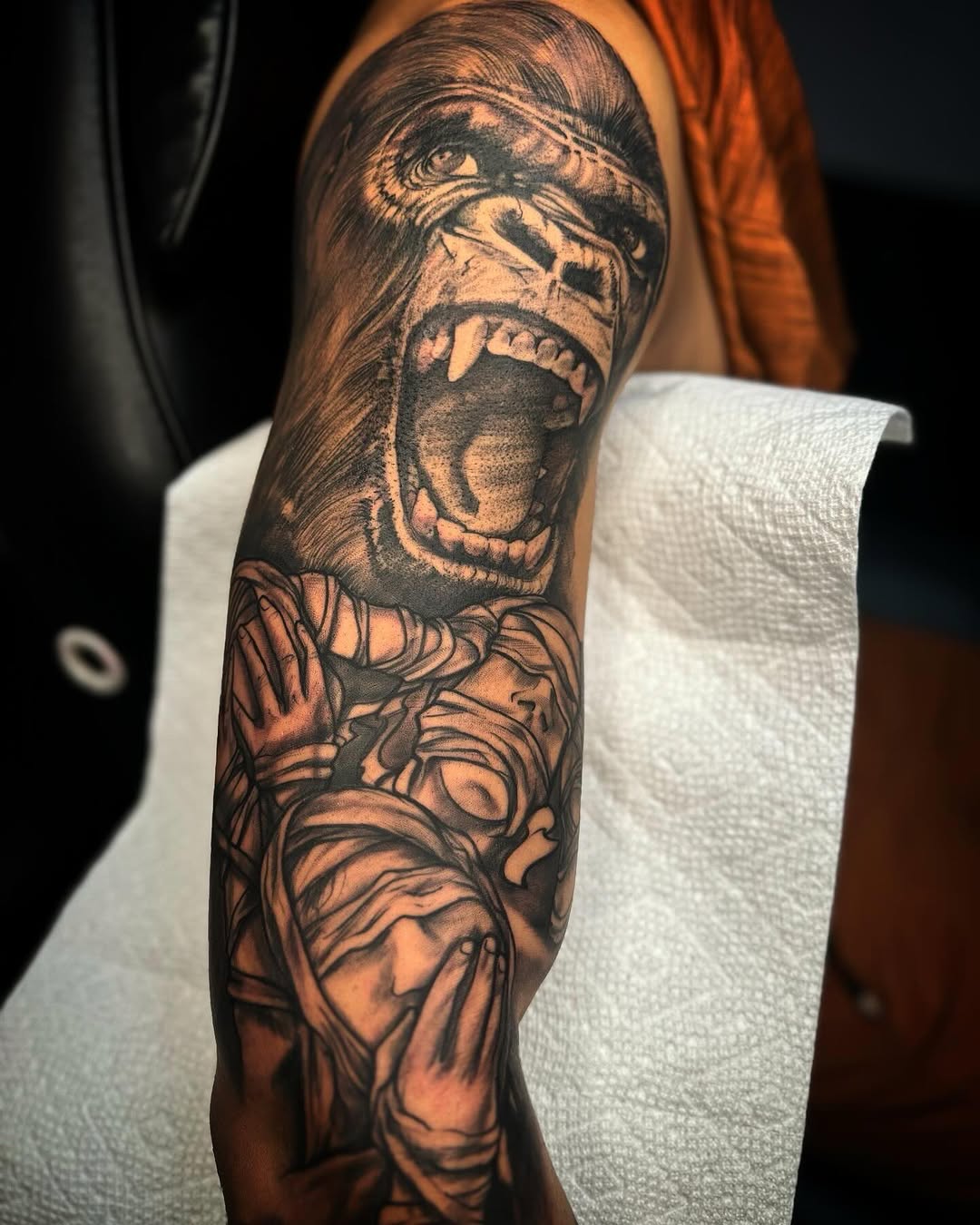 Gorilla and blindfolded figure realism tattoo on the forearm by @inkhazmat