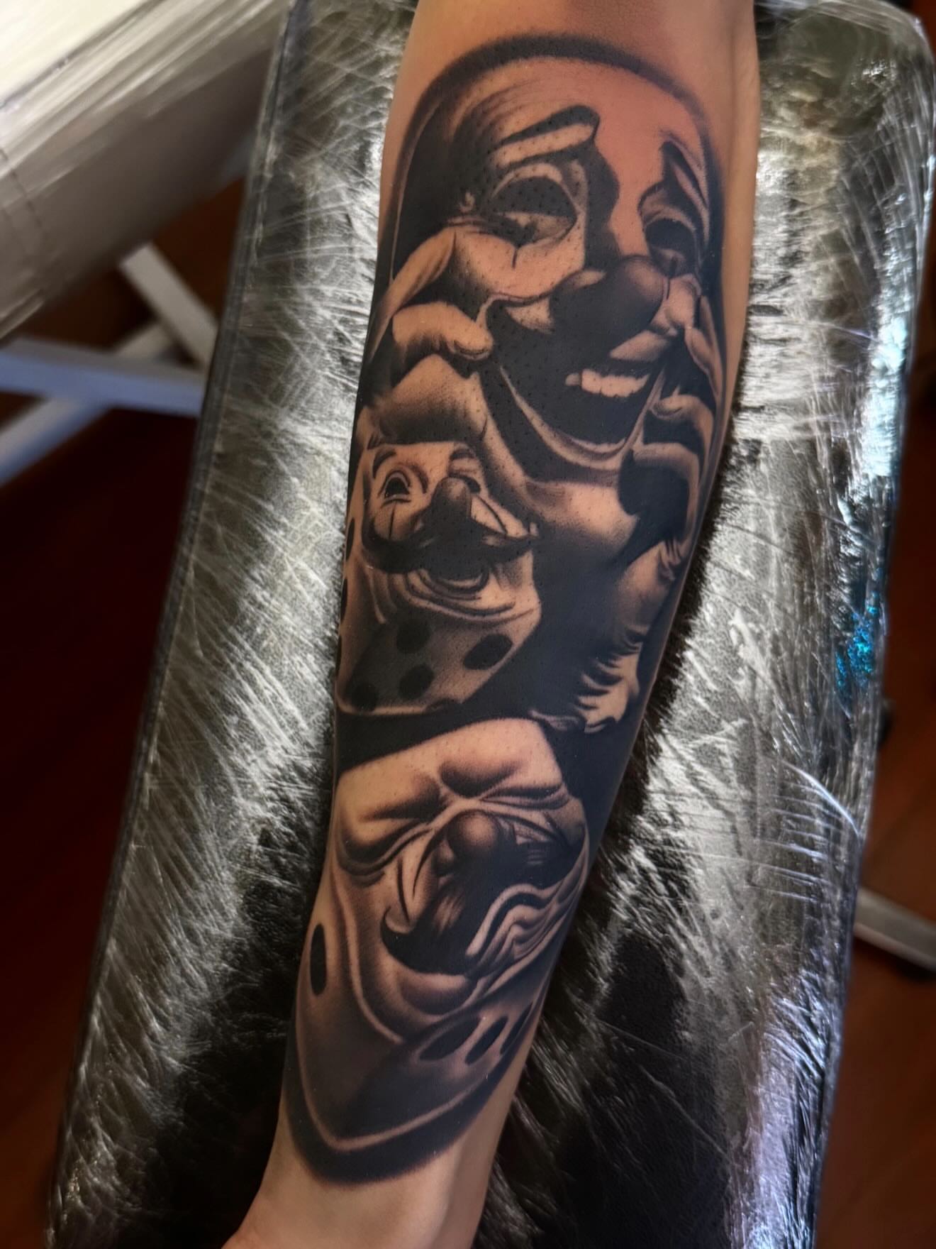Clown black and grey tattoo on the forearm by TattooBoyTattoos