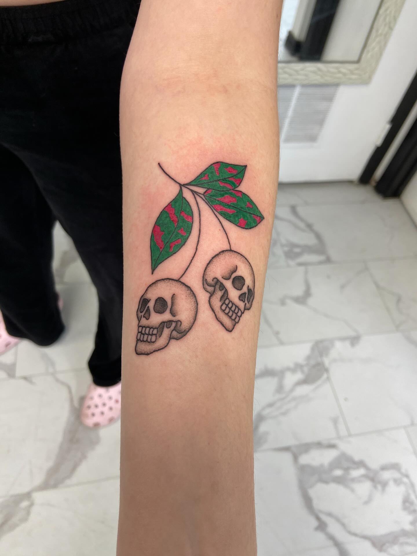 Cherry skulls neo-traditional tattoo on the forearm by Sophia
