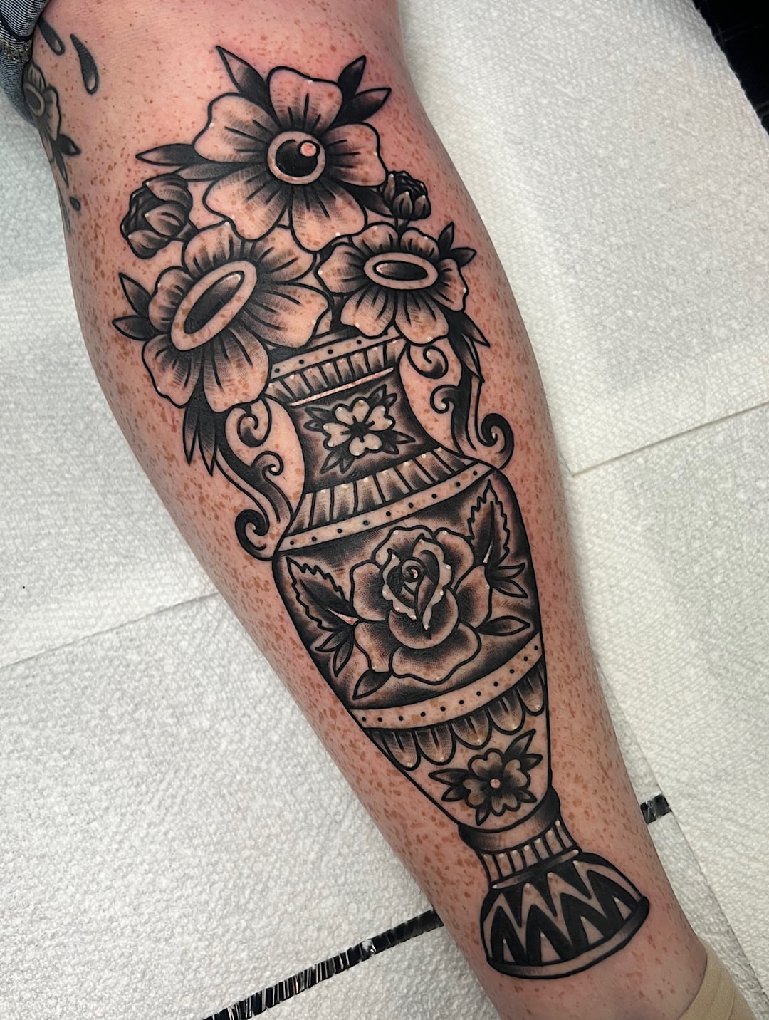 Vase with flowers black and grey tattoo on the forearm by @shannonkeeleyy