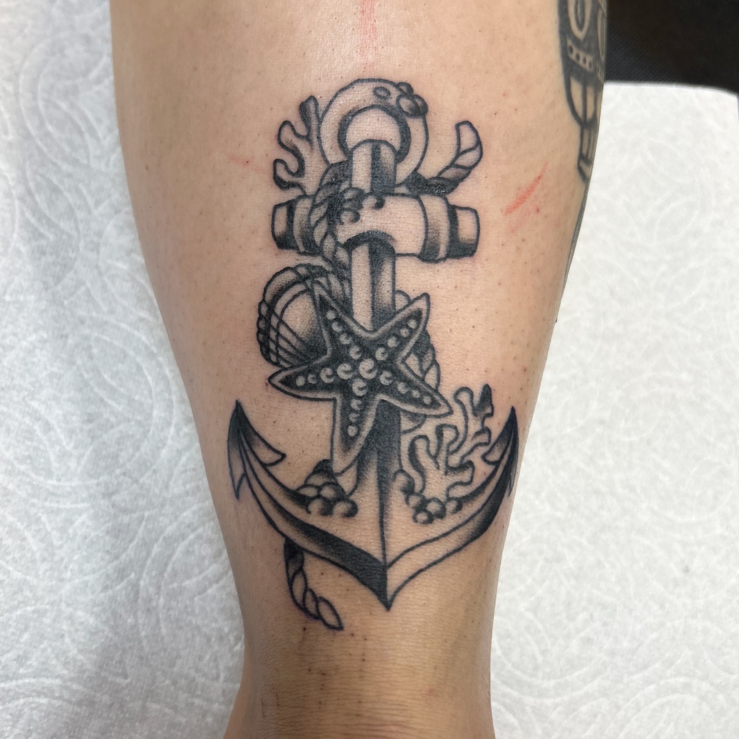 Anchor with starfish black and grey tattoo on the forearm by Vivian Nguyen