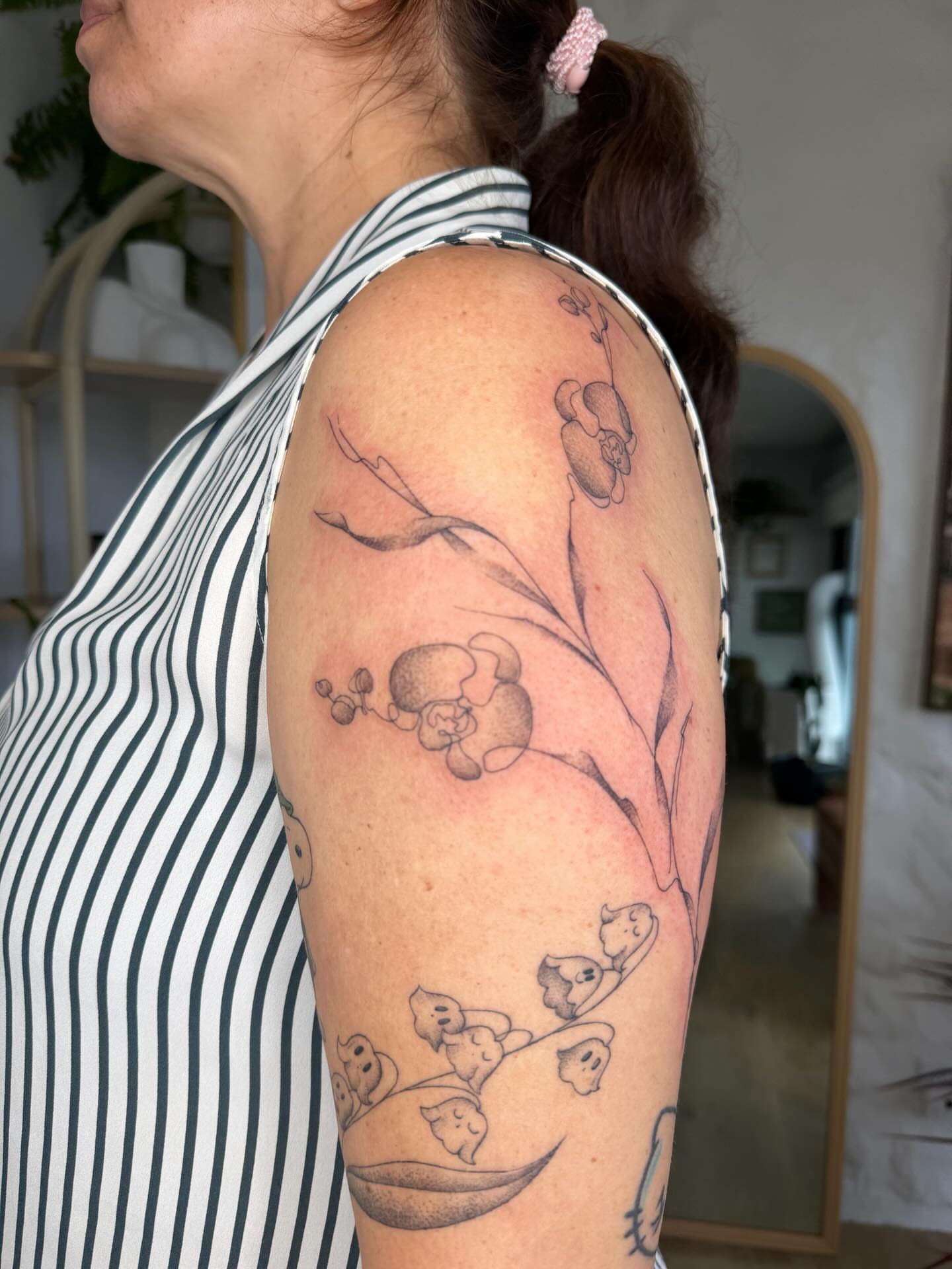 Koala and flowers black and grey tattoo on the upper arm by Priscila - HAWAII TATTOO