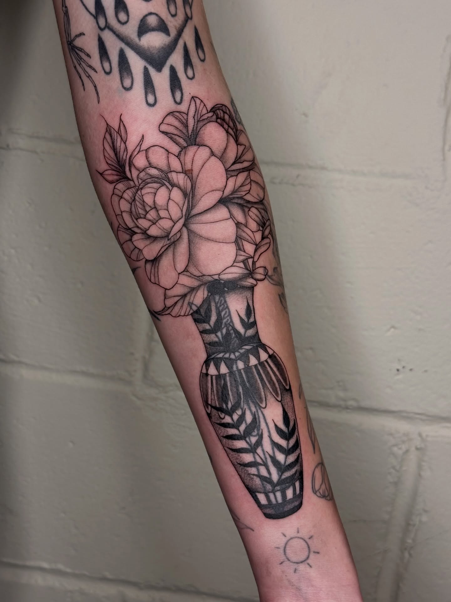 Flower arrangement black and grey tattoo on the forearm by father