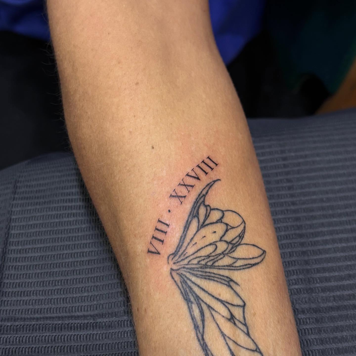 Roman numerals and flower black and grey tattoo on the forearm by Jennifer Flores