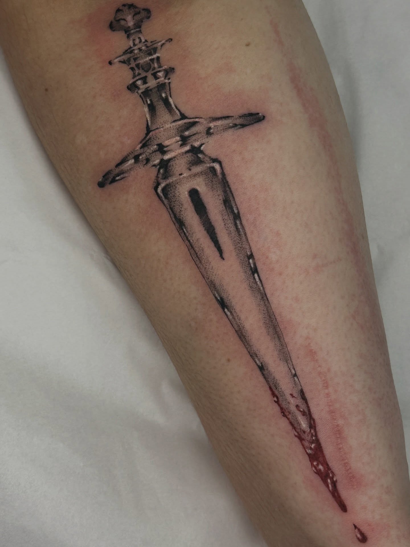 Sword black and grey tattoo on the forearm by Halle Cooper