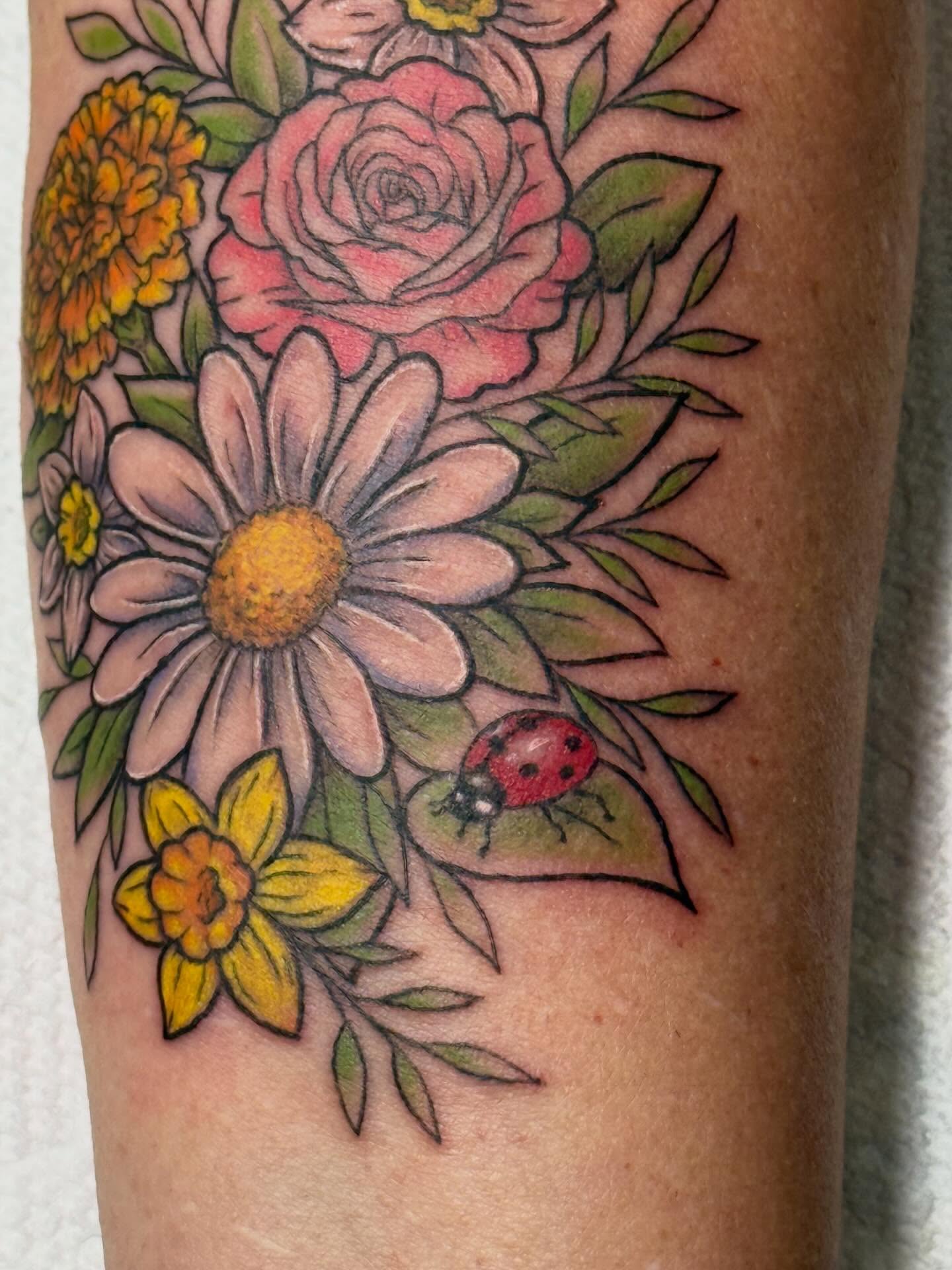 Floral bouquet realism tattoo on the forearm by Camryn Justice