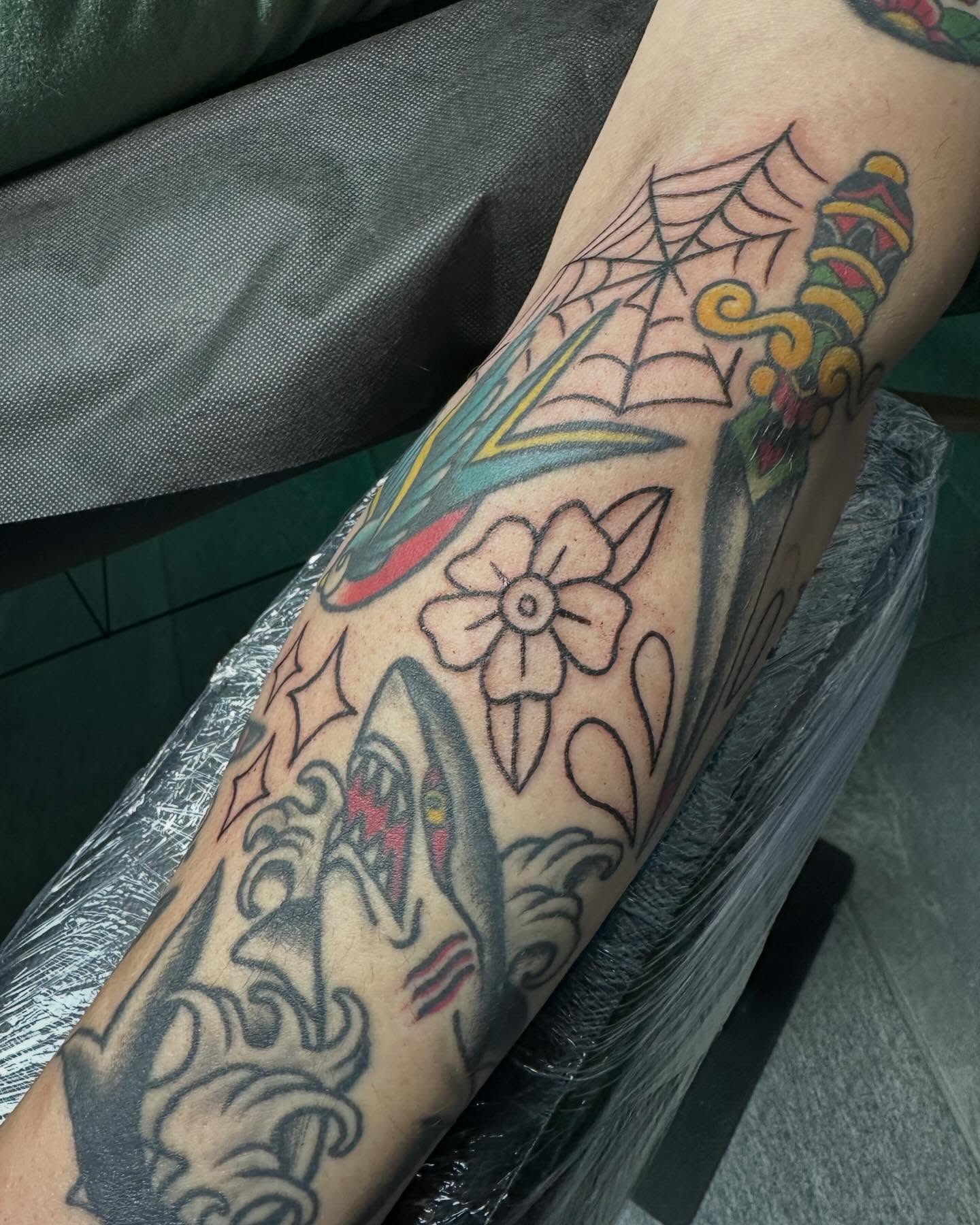 Flower and spider web American traditional tattoo on the forearm by Mikaila Jean