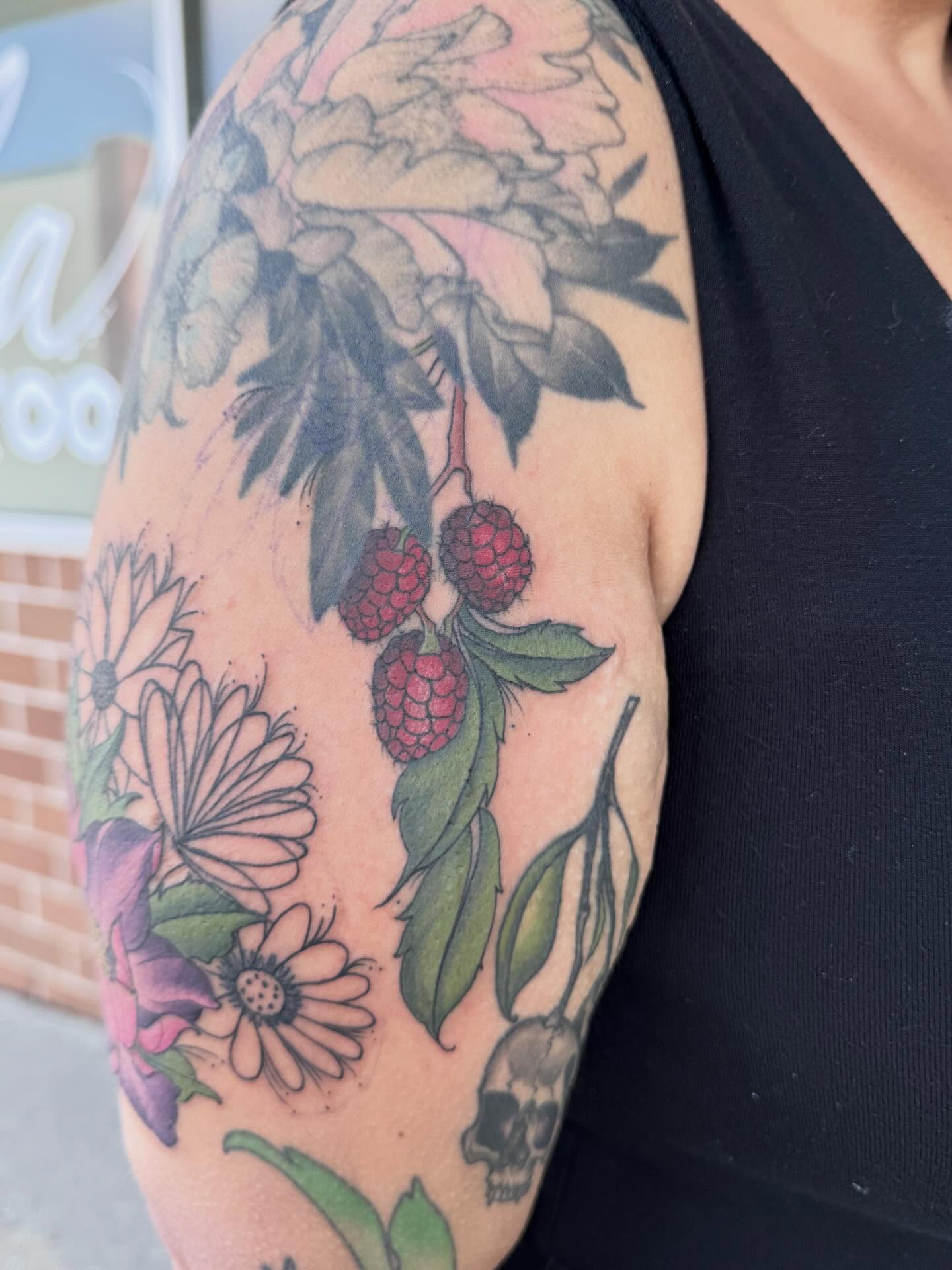 Berries and flowers realism tattoo on the upper arm by Murbee