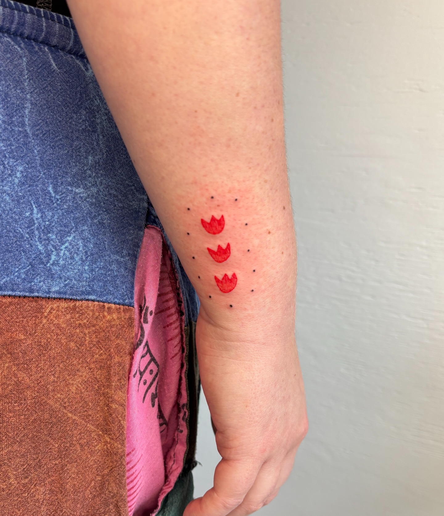 Red tulips dotwork tattoo on the forearm by Raye