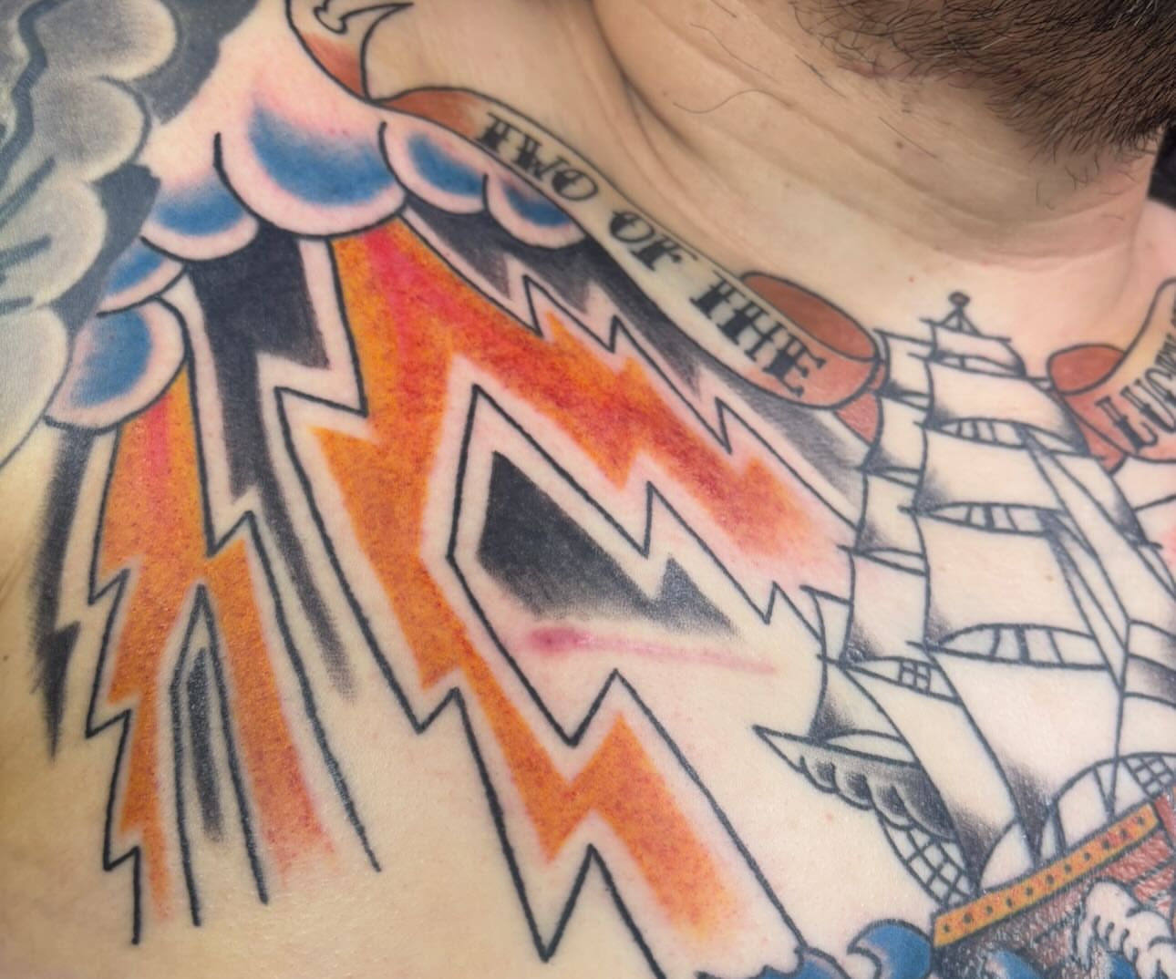 Lightning bolt American traditional tattoo on the chest by Natalie Opal🪻🍎🫖