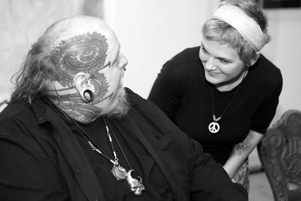 Ear and spiral black and grey tattoo on the head by Paul Booth