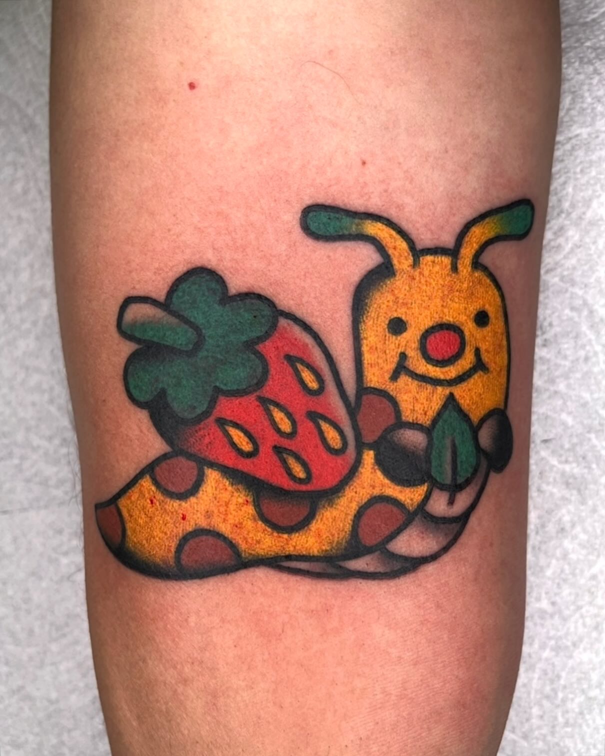 Snail and strawberry new school tattoo on the forearm by Robyn Fricke