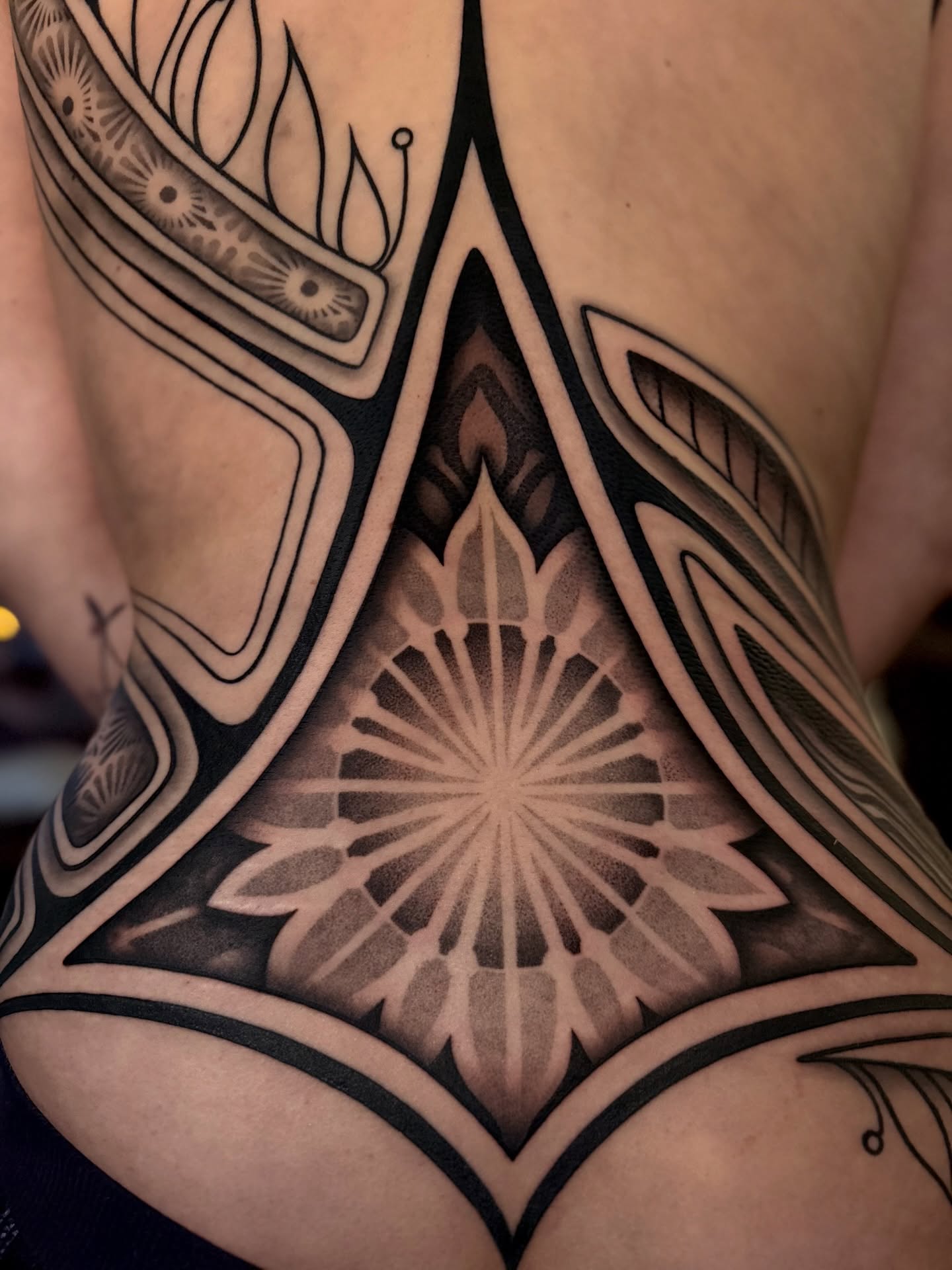 Geometric mandala geometric tattoo on the torso by Haley Corinne