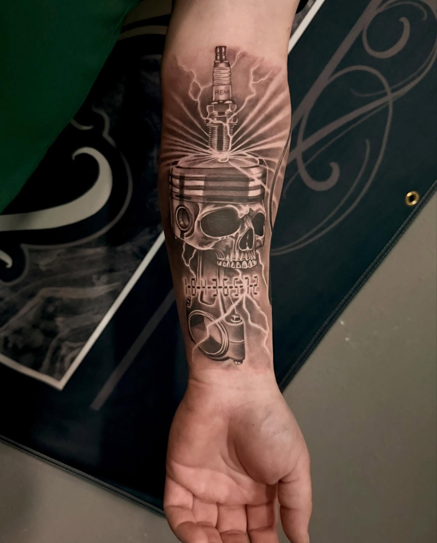 Skull and piston realism tattoo on the forearm by Cody Pappas