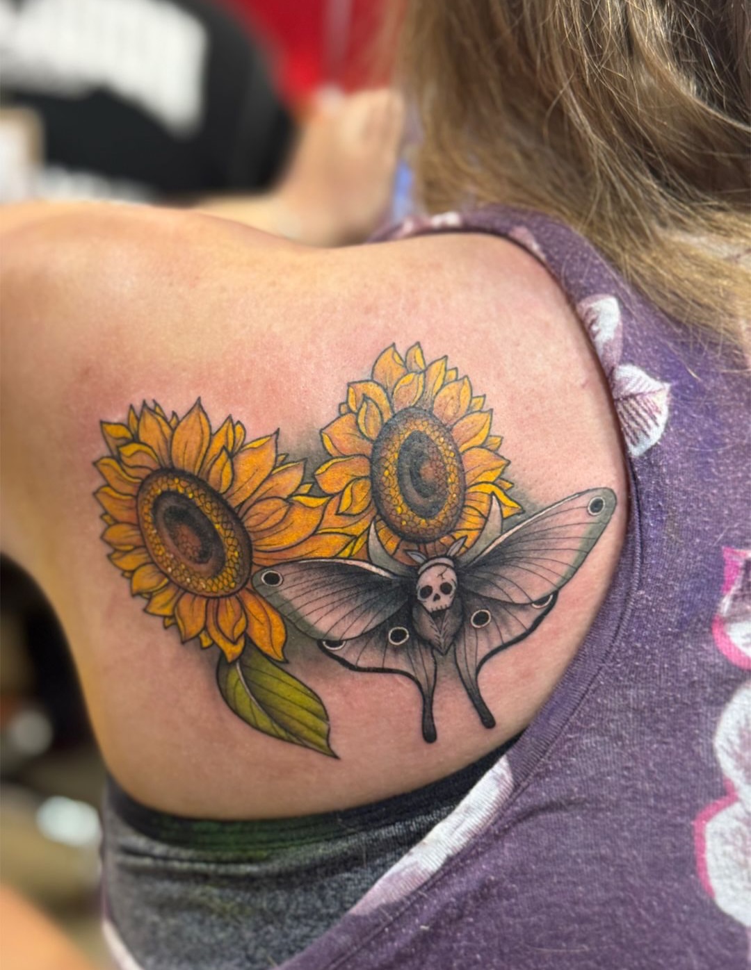 Sunflowers and moth realism tattoo on the shoulder by North County Sd