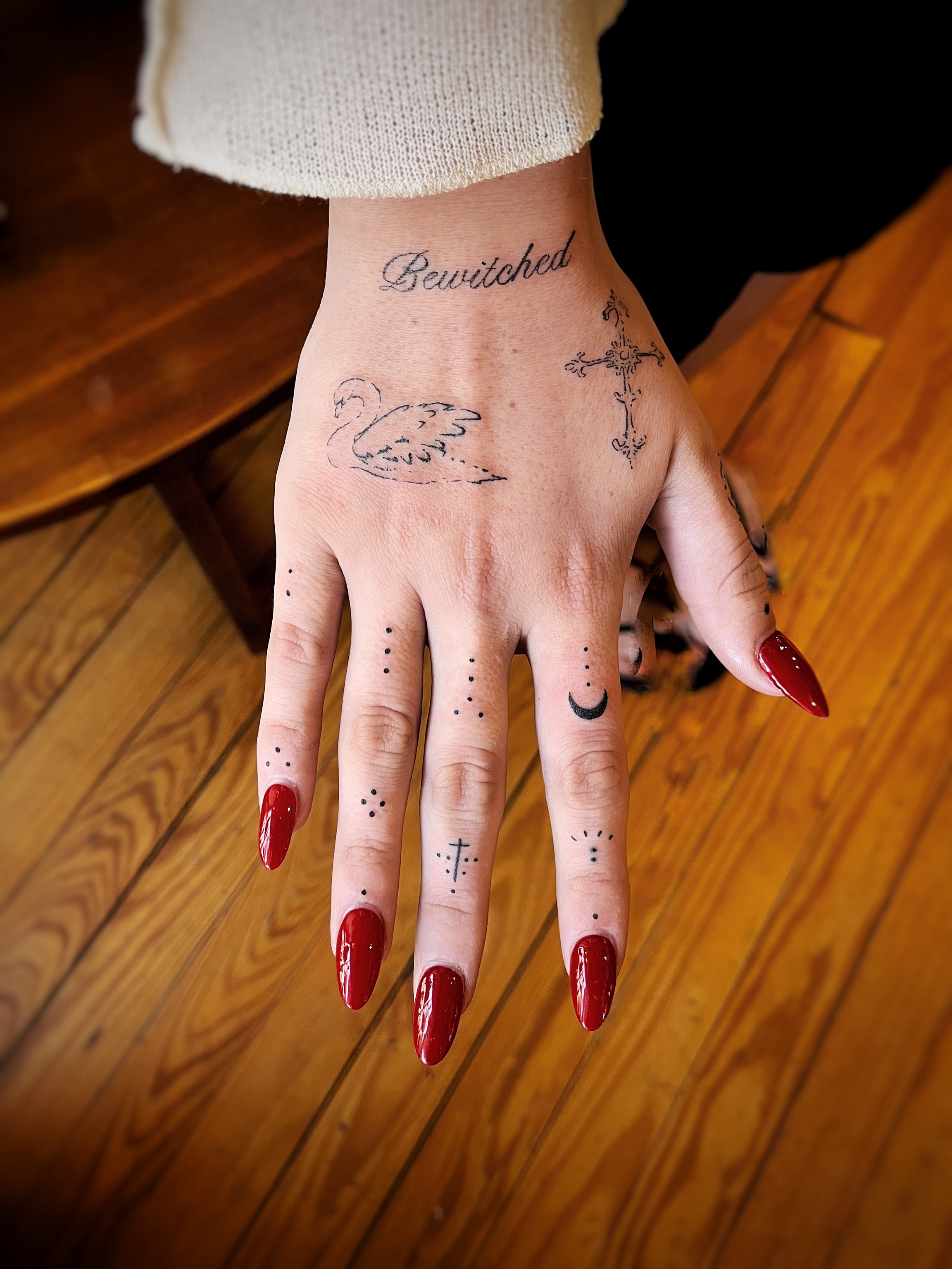 Swan wing and cross dotwork tattoo on the hand by Risa Cincinnati Tattoo Artist