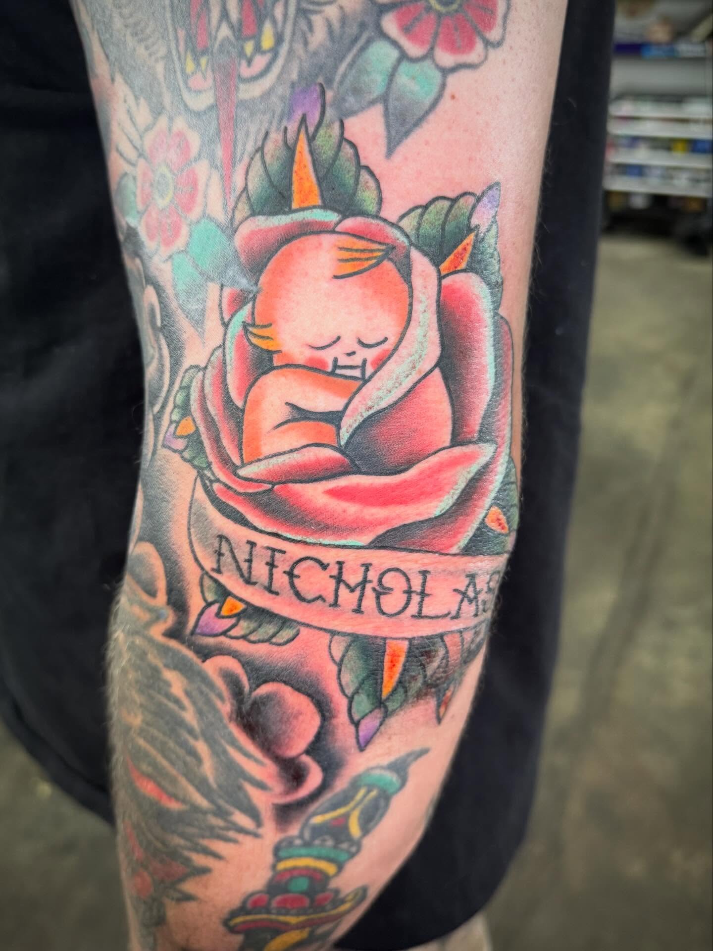 Sleeping baby in rose American traditional tattoo on the forearm by Jake Horstman, Dayton, Ohio