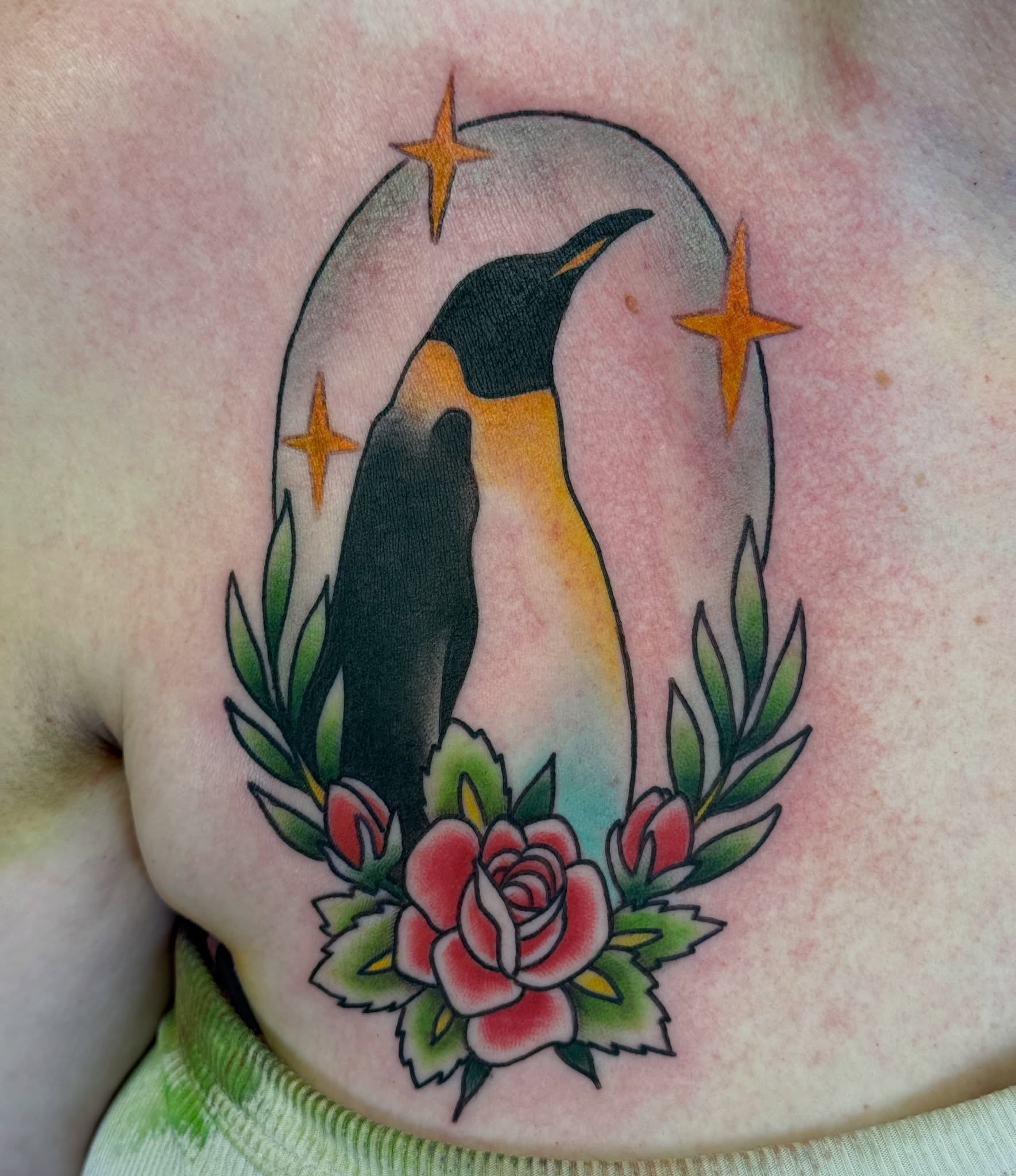 Penguin and roses American traditional tattoo on the chest by Kelsey Louis, Iowa City, Iowa