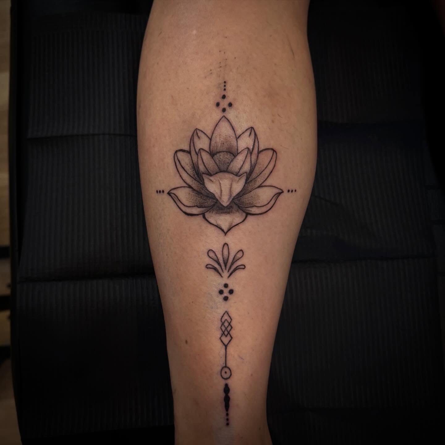 Lotus flower dotwork tattoo on the calf by TolzinInk, Brookings, South Dakota