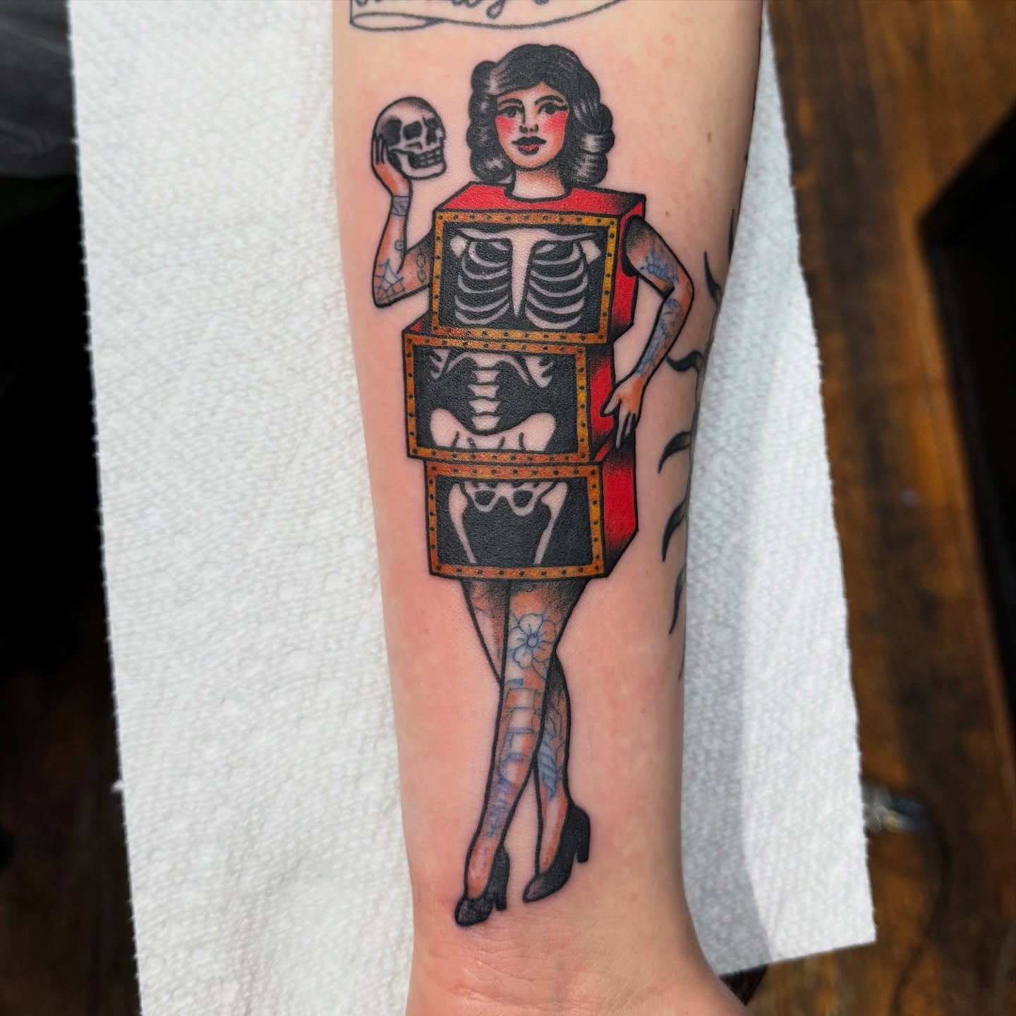 Woman with skeleton American traditional tattoo on the forearm by kenneth nash