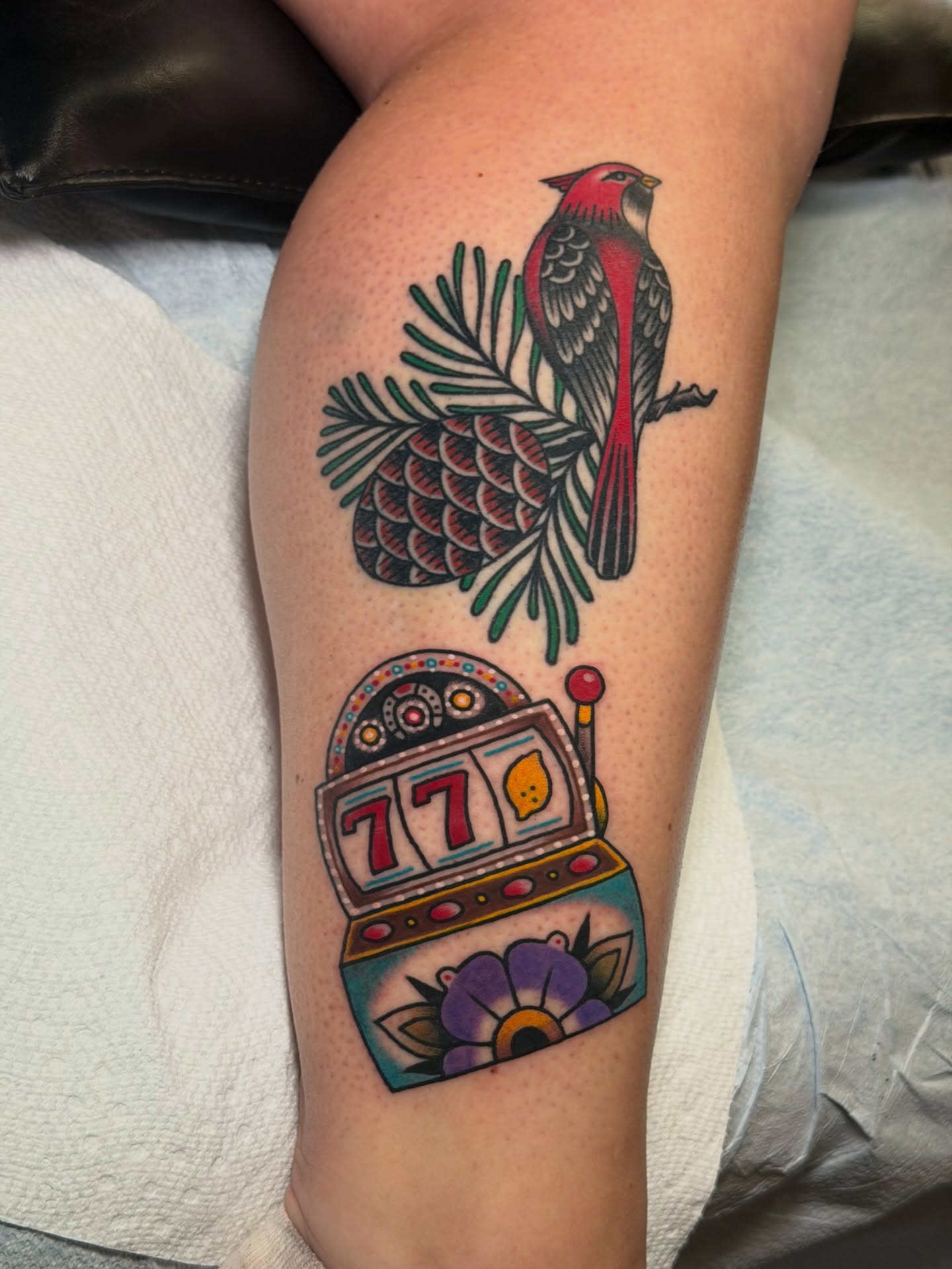 Cardinal and slot machine American traditional tattoo on the thigh by Brandon Bear