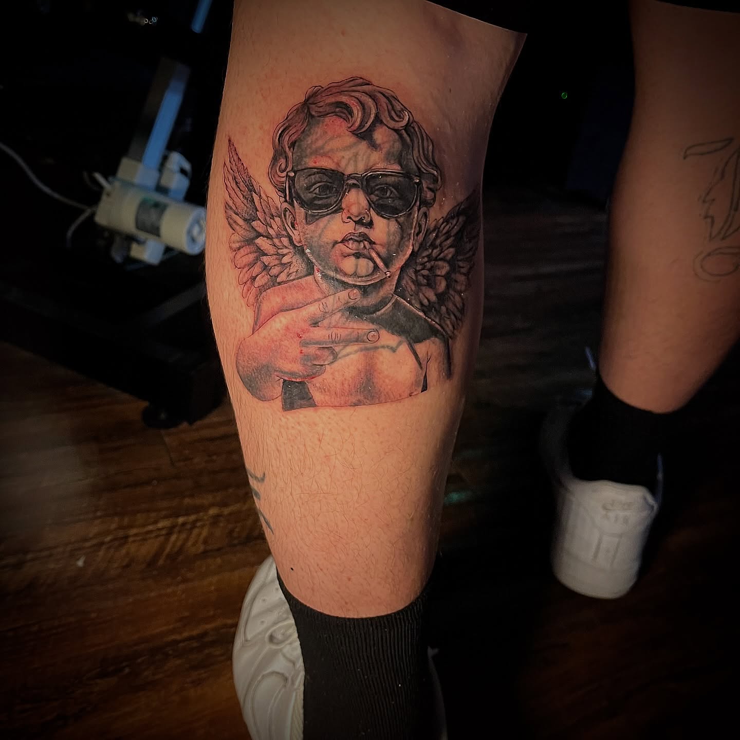 Angels with sunglasses realism tattoo on the thigh by Christa Martinez