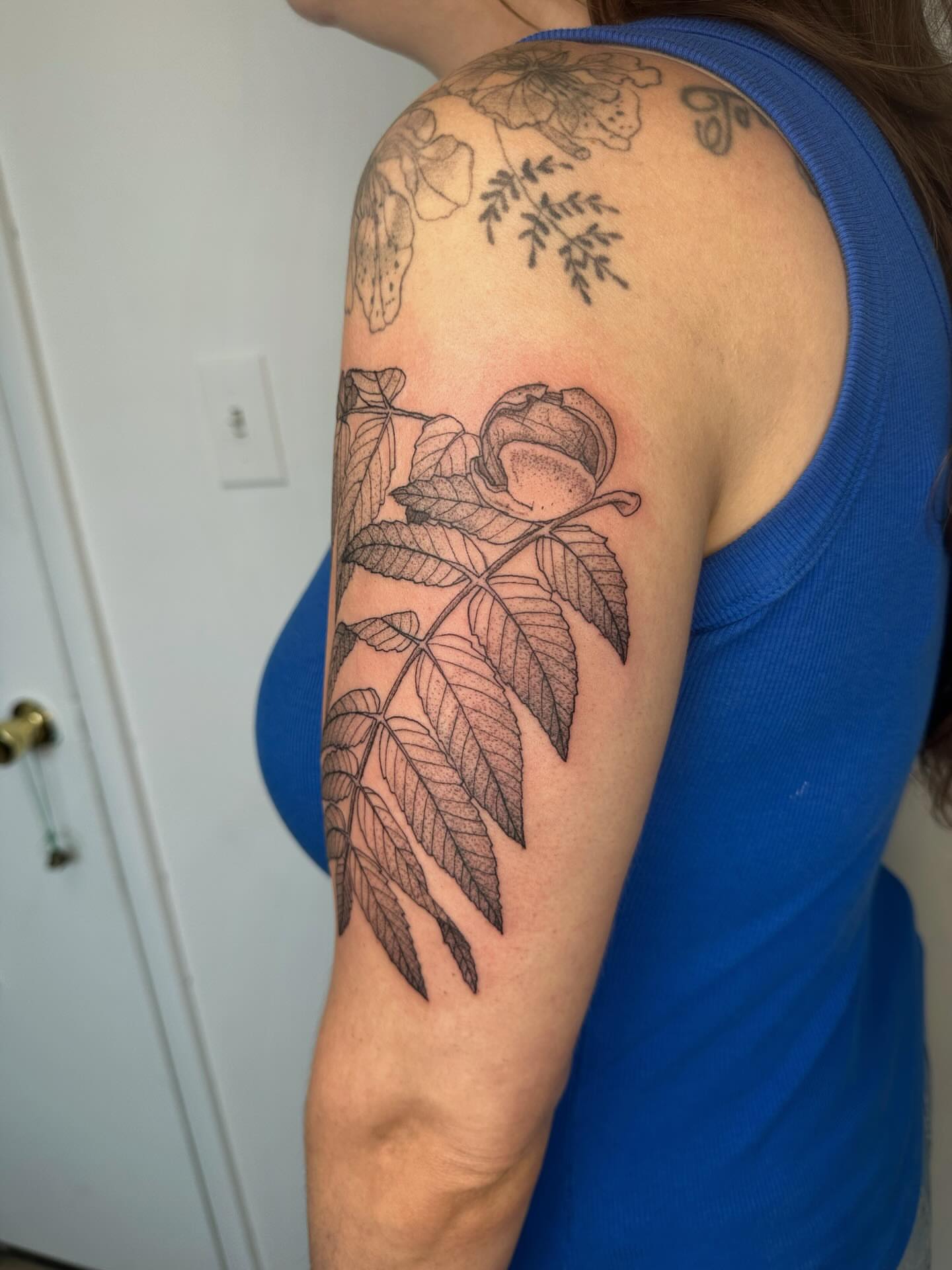 Botanical black and grey tattoo on the upper arm by J Valentin