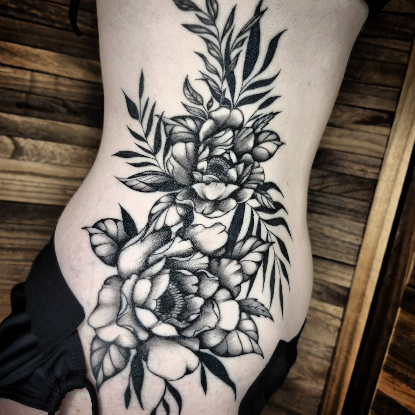Peony flowers black and grey tattoo on the thigh by Kelly Zito