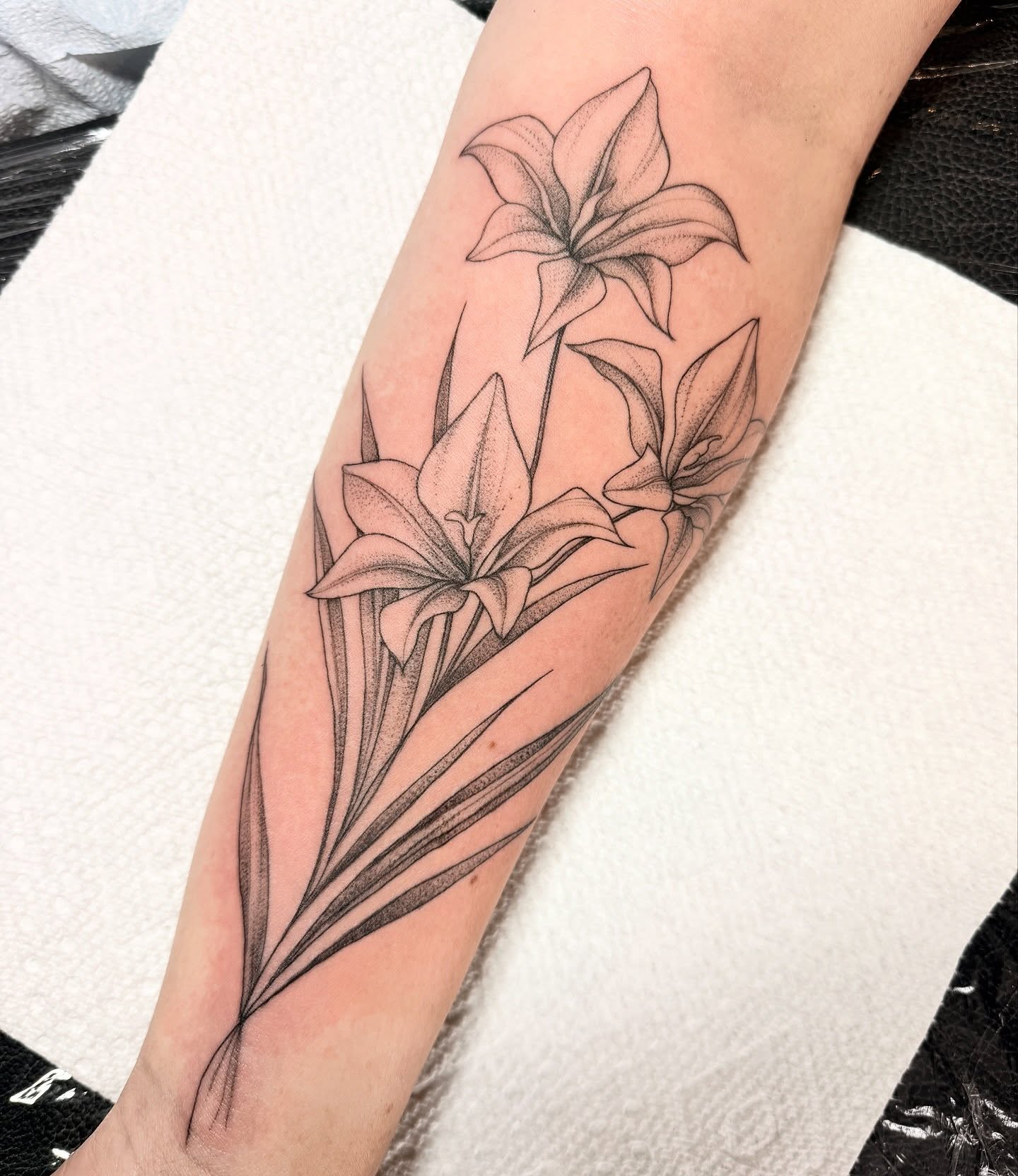 Lilies dotwork tattoo on the forearm by Robert McCollum