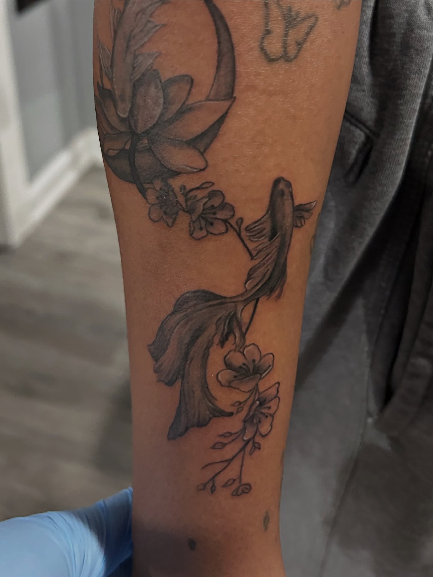 Fish and flowers black and grey tattoo on the forearm by Oto_art