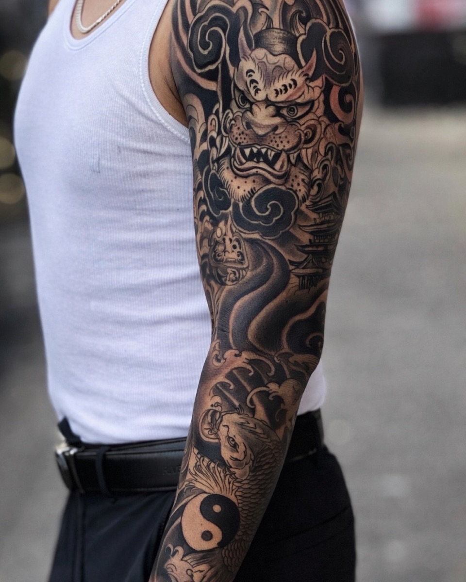Foo dog, koi, and yin yang Japanese tattoo on the upper arm by Andres Calvo🇺🇸🇨🇴