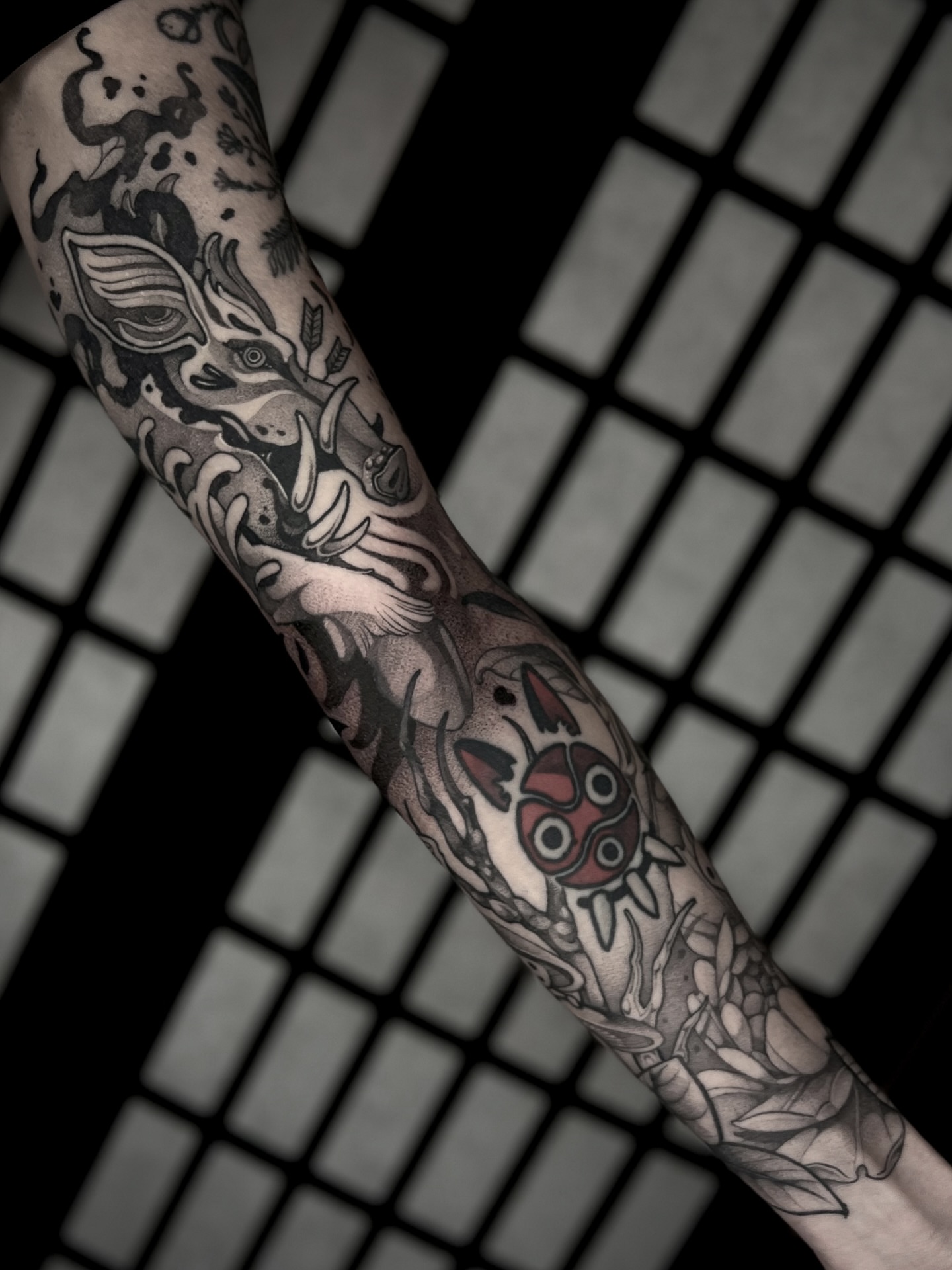 Mask and mythical creature black and grey tattoo on the forearm by Kaysee Shuster